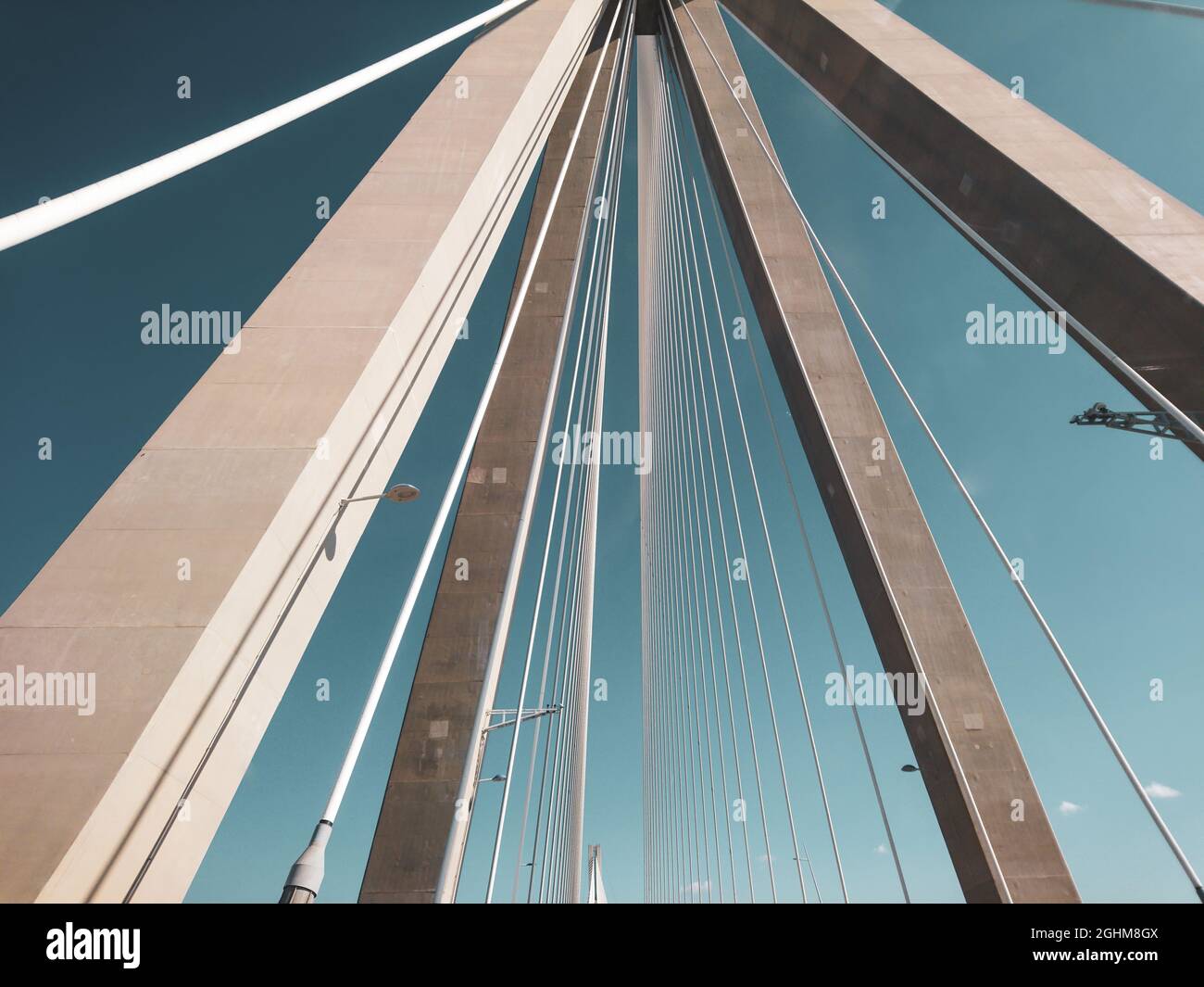 Rion-Antirion Brücke Bau Stahlturm mit Drähten auf Autobahn Straße, Griechenland. Suspension, die zweitlängste Seilbrücke auf sonnigem, landschaftlich schönem Blau Stockfoto