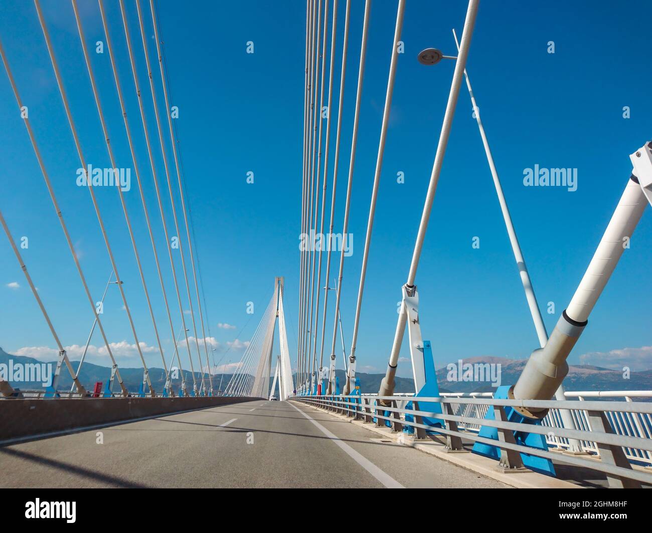 Fahren der Rion-Antirion Brücke auf der Autobahn in Patras Stadt, Griechenland. Hängebrücke am Golf von Korinth. Die zweitlängste Brücke mit Kabelgestabeung. Sonnensumpf Stockfoto