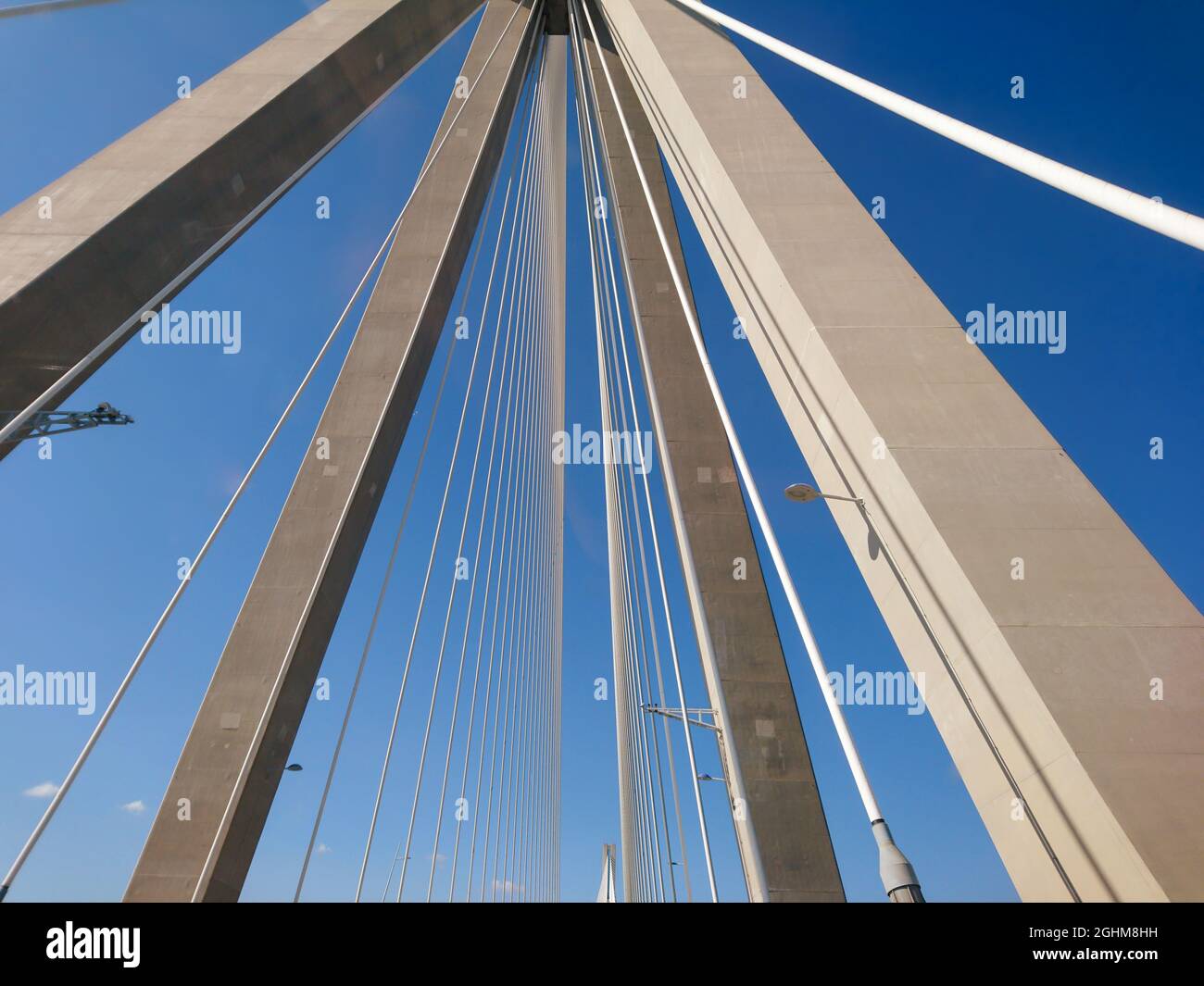 Rion-Antirion Brücke Bau Stahlturm mit Drähten auf Autobahn Straße, Griechenland. Suspension, die zweitlängste Seilbrücke auf sonnigem, landschaftlich schönem Blau Stockfoto