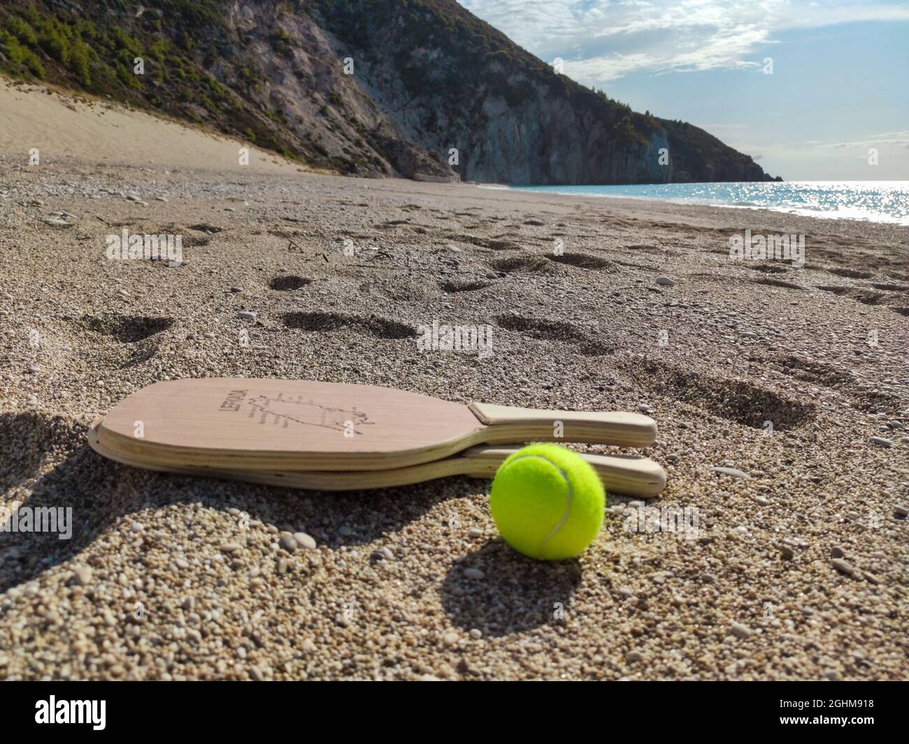 Matkot griechisches Paddle Beach Tennis Spiel mit Ball und Holzschlägern mit Karte der Insel Lefkada, Mylos Strand. Sportausrüstung am Sandstrand in Griechenland Stockfoto