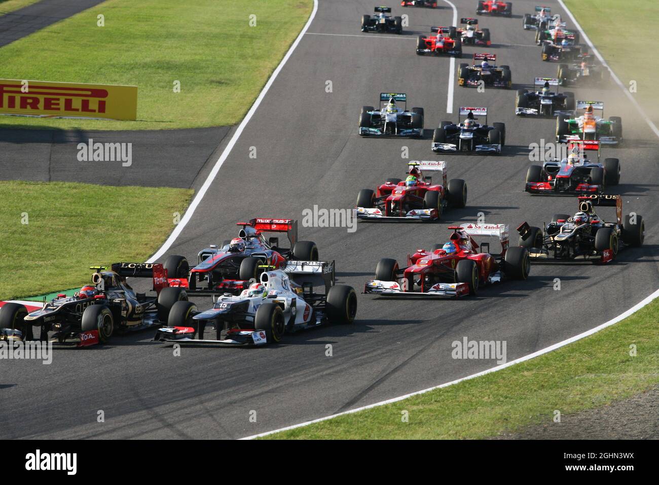 Fernando Alonso (ESP) Ferrari F2012 und Kimi Räikkönen (FIN) Lotus F1 E20 nehmen Kontakt zum Start des Rennens auf. 07.10.2012. Formel 1 Weltmeisterschaft, Rd 15, Großer Preis Von Japan, Suzuka, Japan, Wettkampftag. Stockfoto