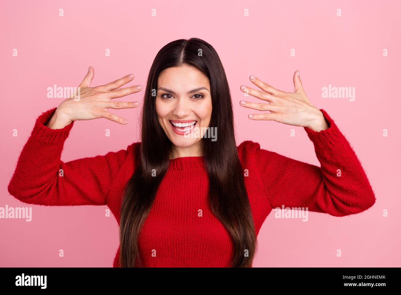 Foto von beeindruckt Brünette Dame zeigen Nägel tragen roten Pullover isoliert auf rosa Hintergrund Stockfoto