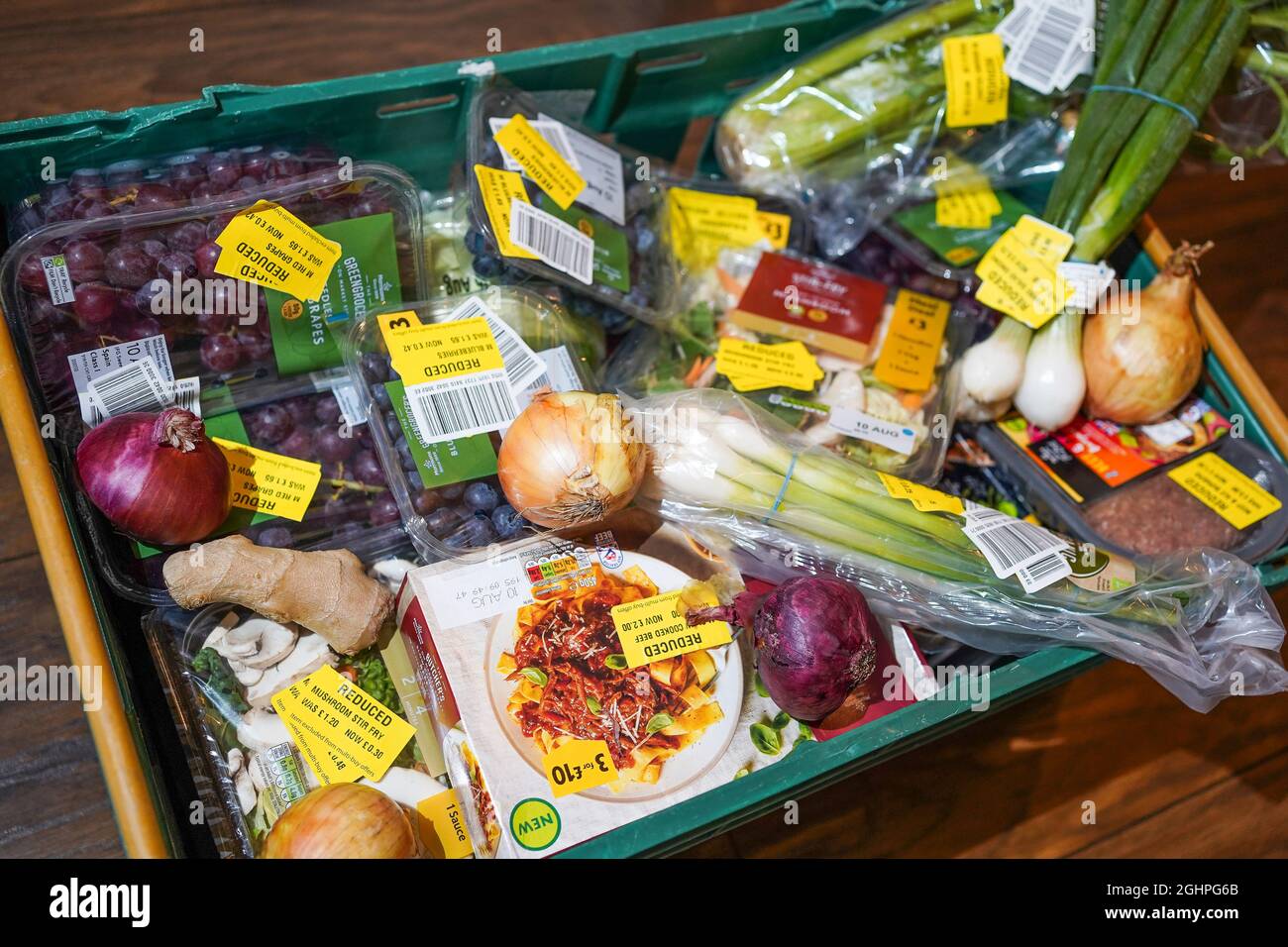 Lebensmittelprodukte in Supermärkten mit reduzierten gelben Aufklebern aufgrund der kurzen Haltbarkeit, veralgerte Kennzeichnung. Reduzierung und Vermeidung von Lebensmittelabfällen im Vereinigten Königreich. Stockfoto