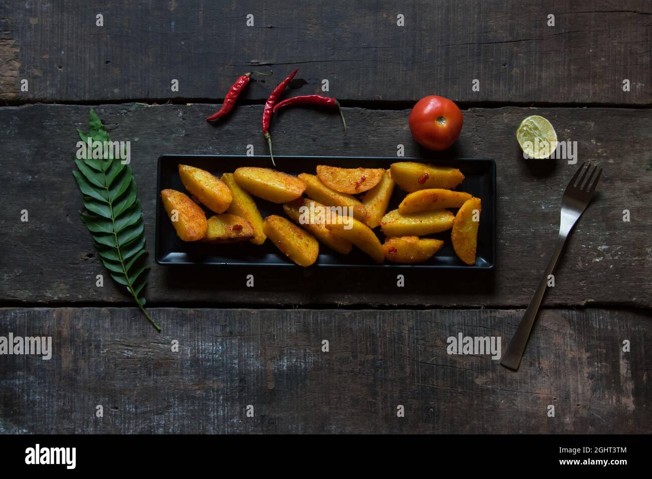 Snacks, gebackene und knusprige Kartoffelkeile, serviert mit Zutaten. Draufsicht. Stockfoto