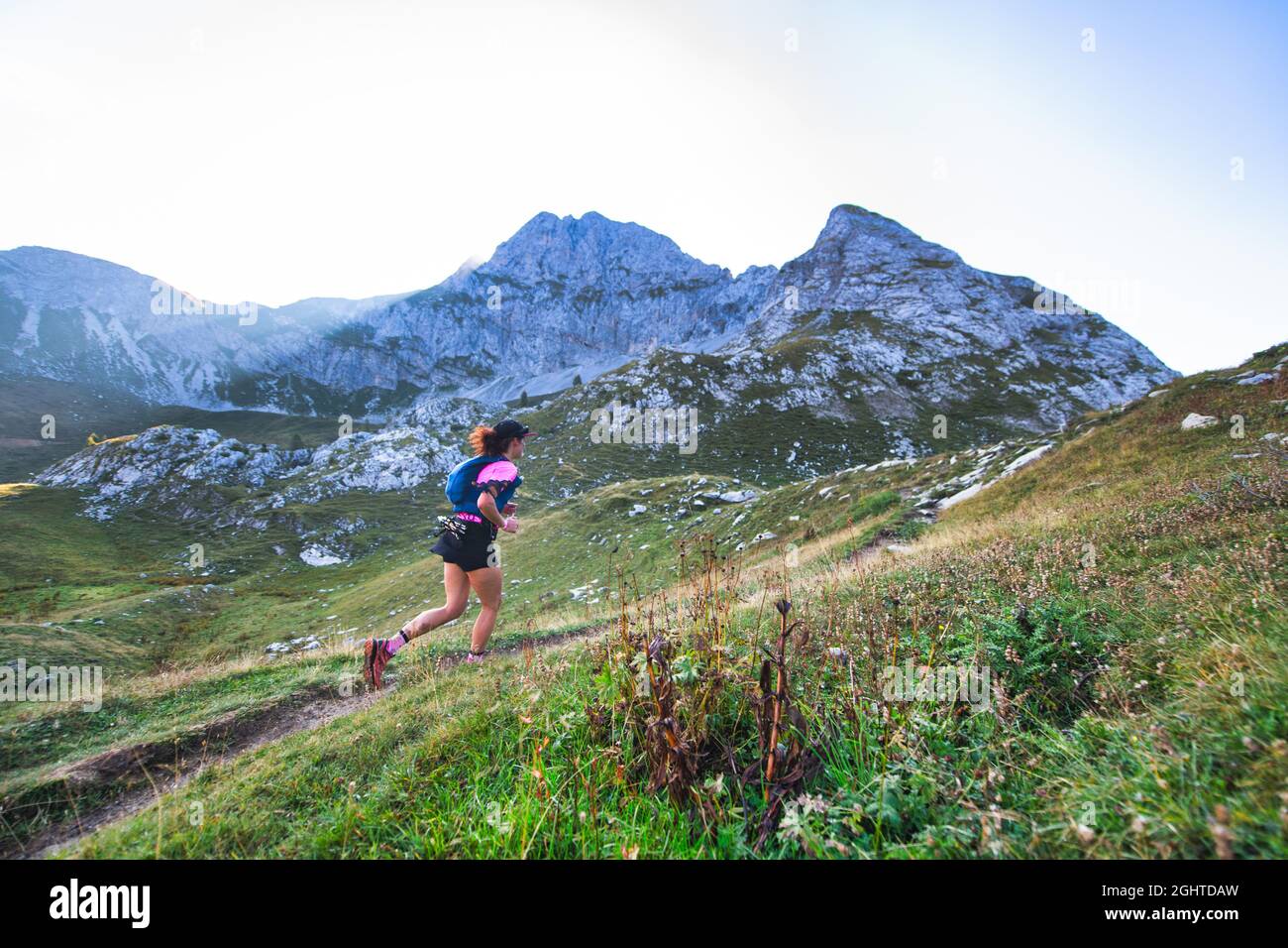 Sportliche Bergfrau fährt im Ausdauertraining auf dem Trail Stockfoto