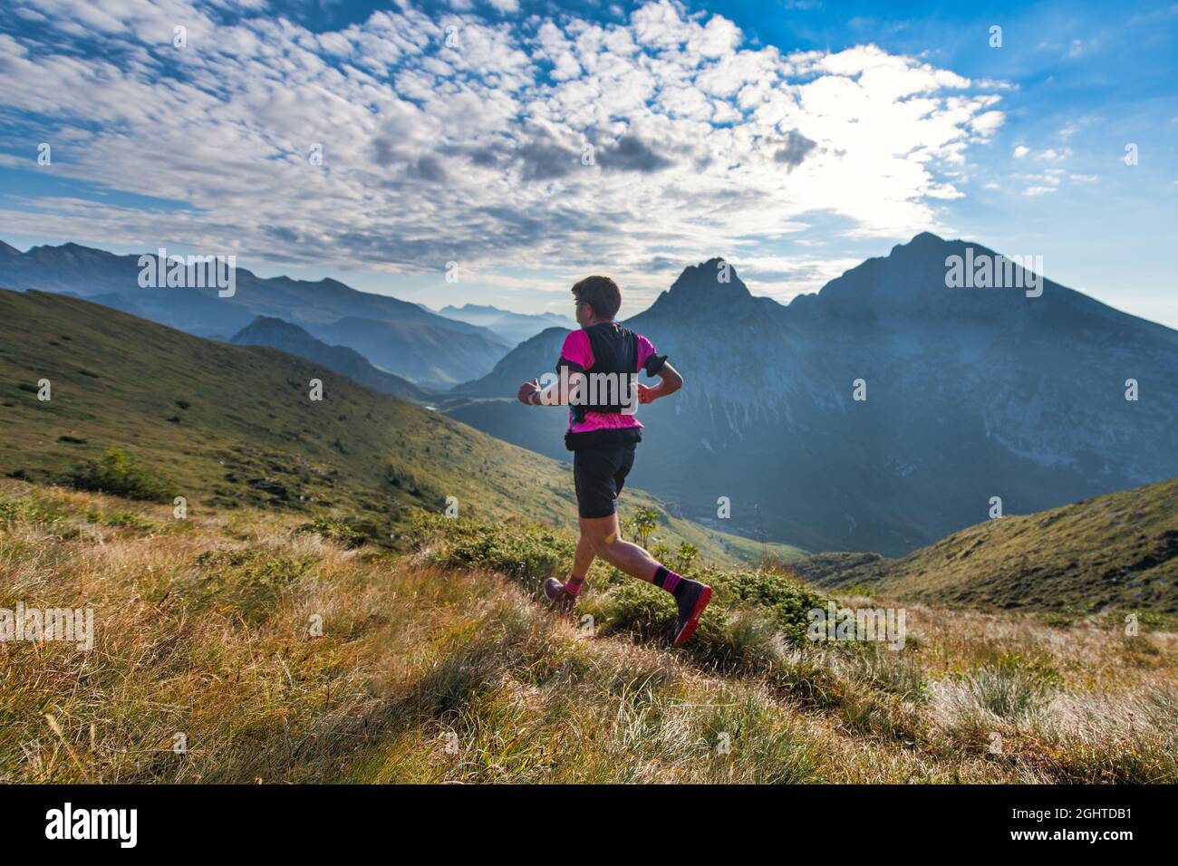 Sportlicher Bergmann fährt während des Ausdauertrainings auf dem Trail Stockfoto