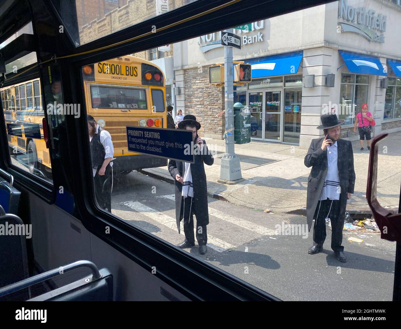 Orthodoxe jüdische Männer auf der Straße von einem Stadtbus entlang der 13th Avenue im Herzen des Geschäftsviertels Borough Park in Brooklyn, New York. Stockfoto