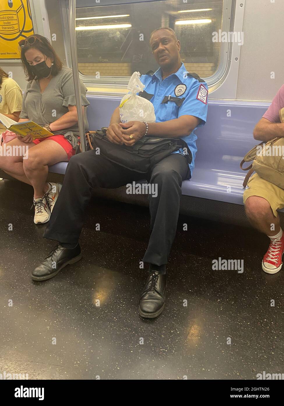 Müder Wachmann, der nach der Arbeit in einer NYC-U-Bahn fährt. New York City. Stockfoto