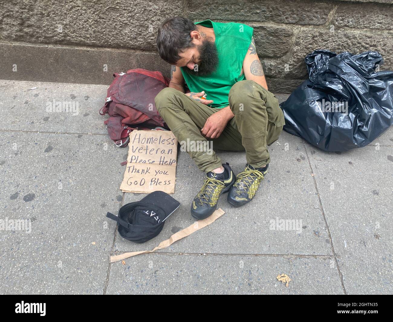 Kriegsopfer: Obdachloser US-Militärveteran schläft auf der Straße und bittet Bryant Park in Midtown Manhattan, New York City, um Hilfe. Stockfoto