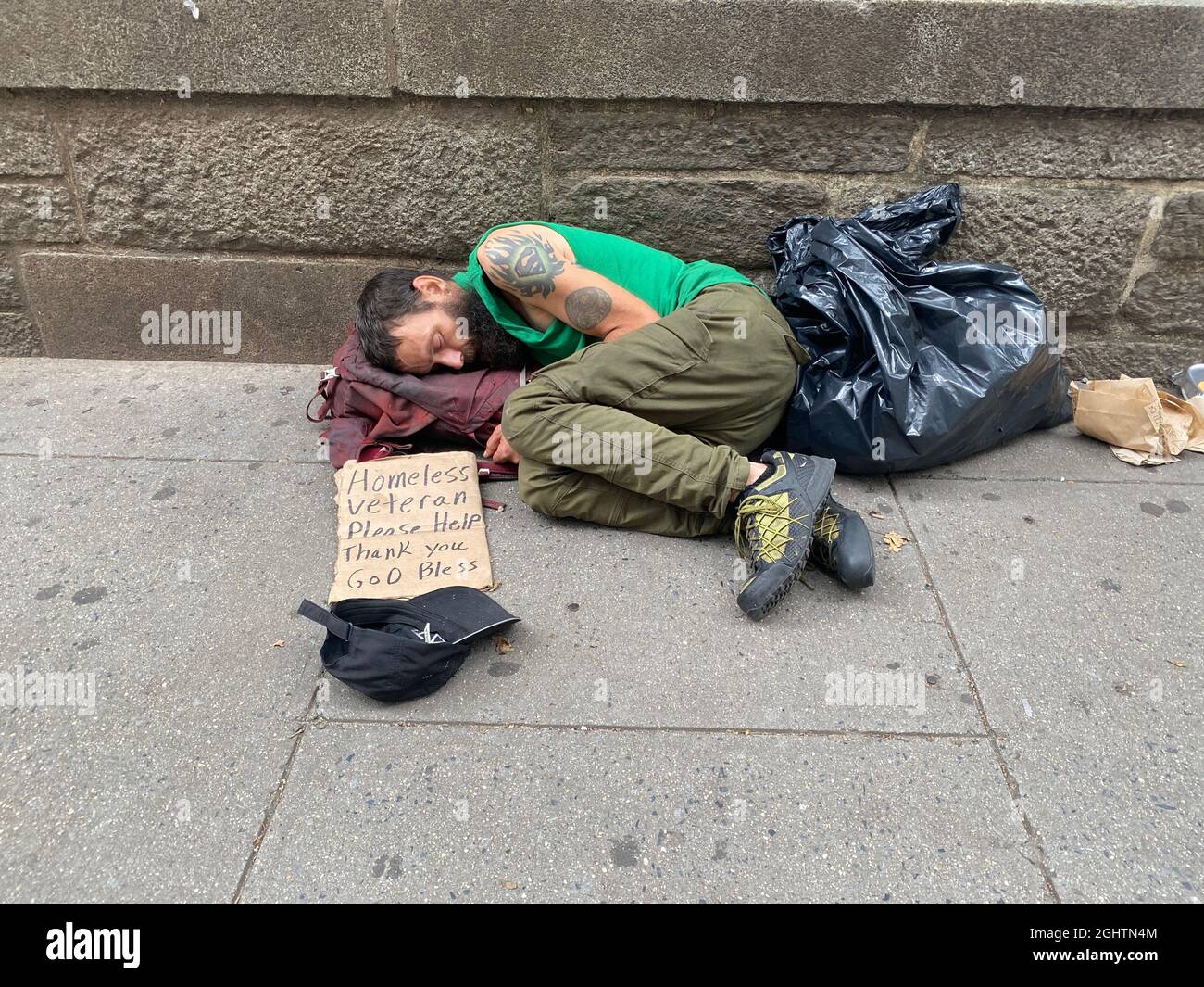 Kriegsopfer: Obdachloser US-Militärveteran schläft auf der Straße und bittet Bryant Park in Midtown Manhattan, New York City, um Hilfe. Stockfoto