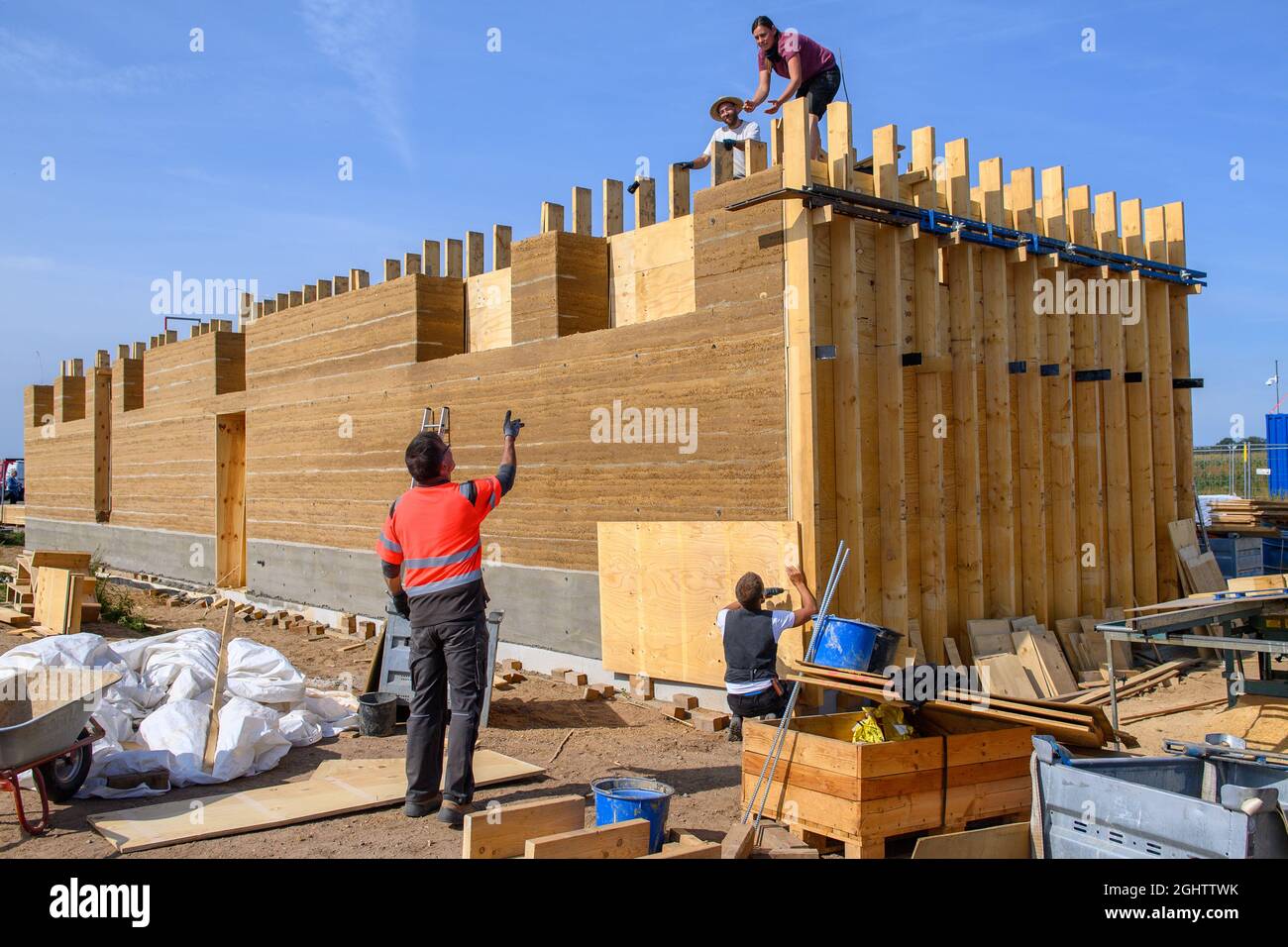07. September 2021, Sachsen-Anhalt, Pömmelte: Unweit des Ringschreins entfernen Arbeiter die Holztäfelungen des dort errichteten Besucherzentrums. Der Rohbau ist nach acht Wochen fertig gestellt und ist der erste Neubau mit tragenden Lehmwänden in Mitteldeutschland. Die Gebäude aus der Stein- und Bronzezeit am Ringschrein wurden vor 4000 Jahren aus Ton und Holz erbaut. Foto: Klaus-Dietmar Gabbert/dpa-Zentralbild/ZB Stockfoto
