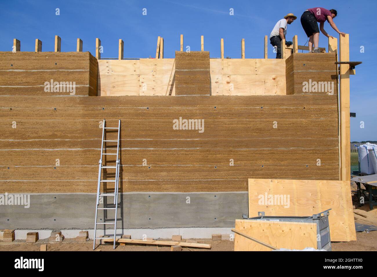 07. September 2021, Sachsen-Anhalt, Pömmelte: Unweit des Ringschreins entfernen Arbeiter die Holztäfelungen des dort errichteten Besucherzentrums. Der Rohbau ist nach acht Wochen fertig gestellt und ist der erste Neubau mit tragenden Lehmwänden in Mitteldeutschland. Die Gebäude aus der Stein- und Bronzezeit am Ringschrein wurden vor 4000 Jahren aus Ton und Holz erbaut. Foto: Klaus-Dietmar Gabbert/dpa-Zentralbild/ZB Stockfoto