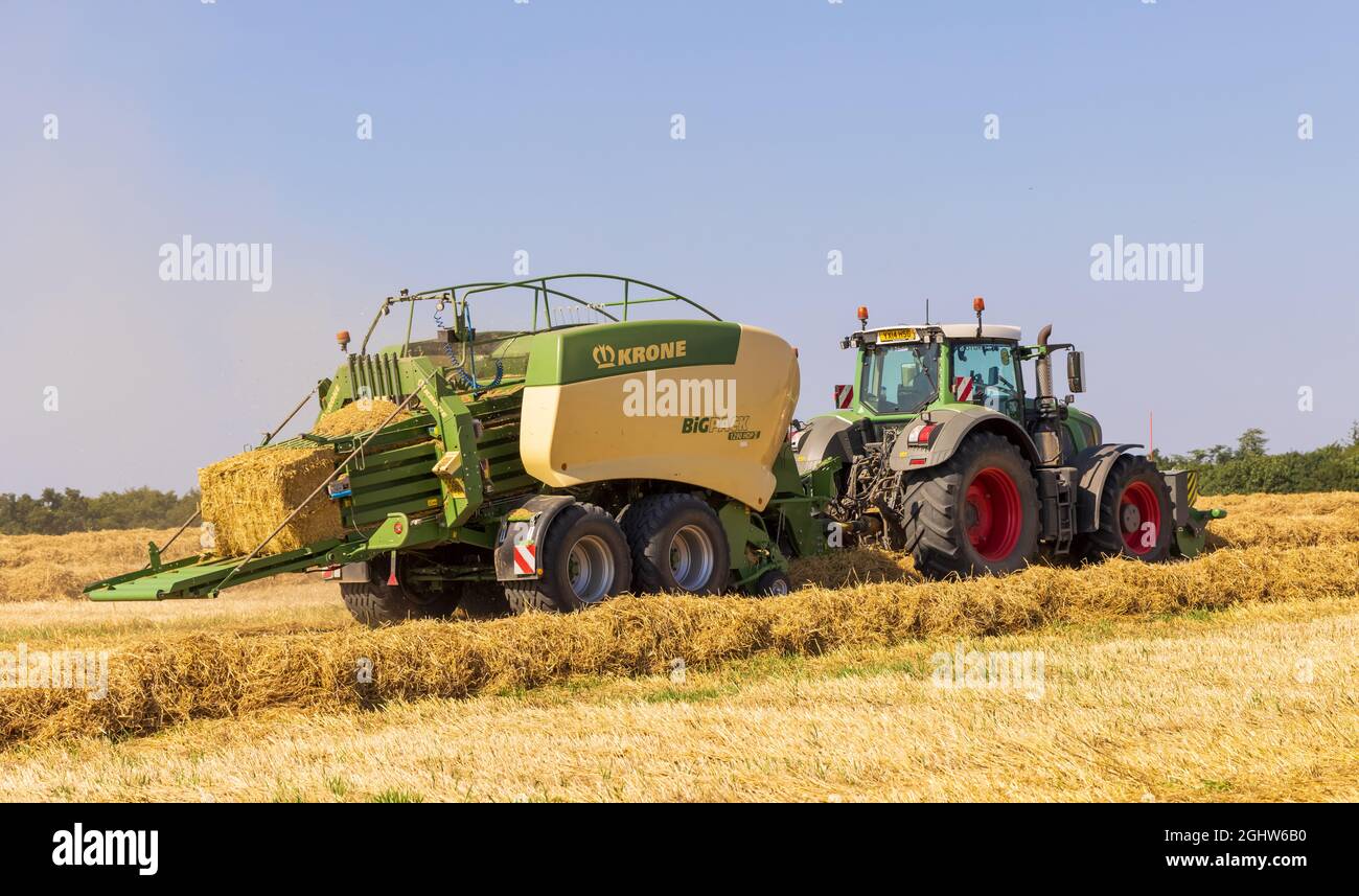Traktor und Ballenpresse und Strohballenpresse auf einem Feld  Stockfotografie - Alamy