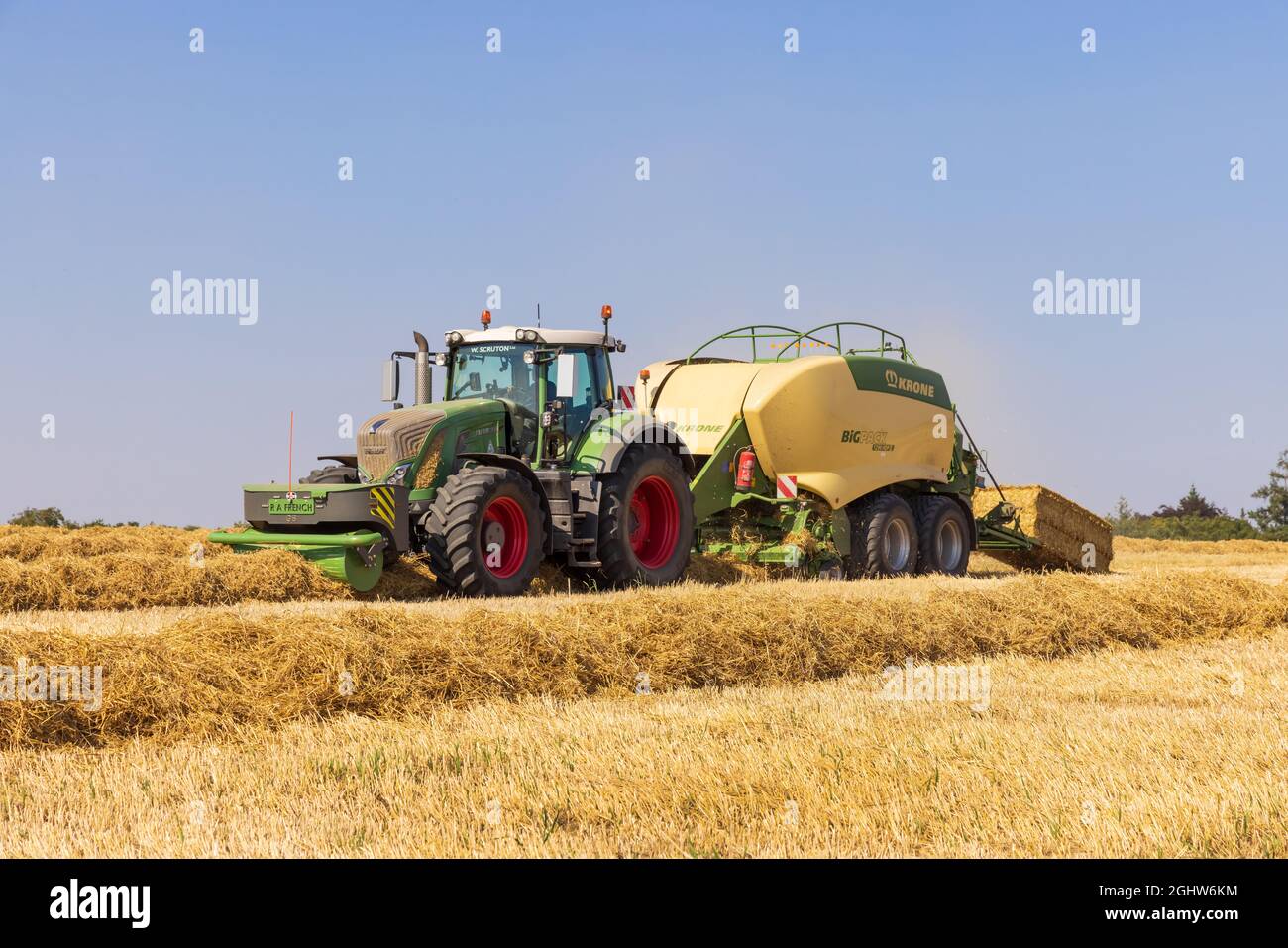 Traktor und Ballenpresse und Strohballenpresse auf einem Feld  Stockfotografie - Alamy