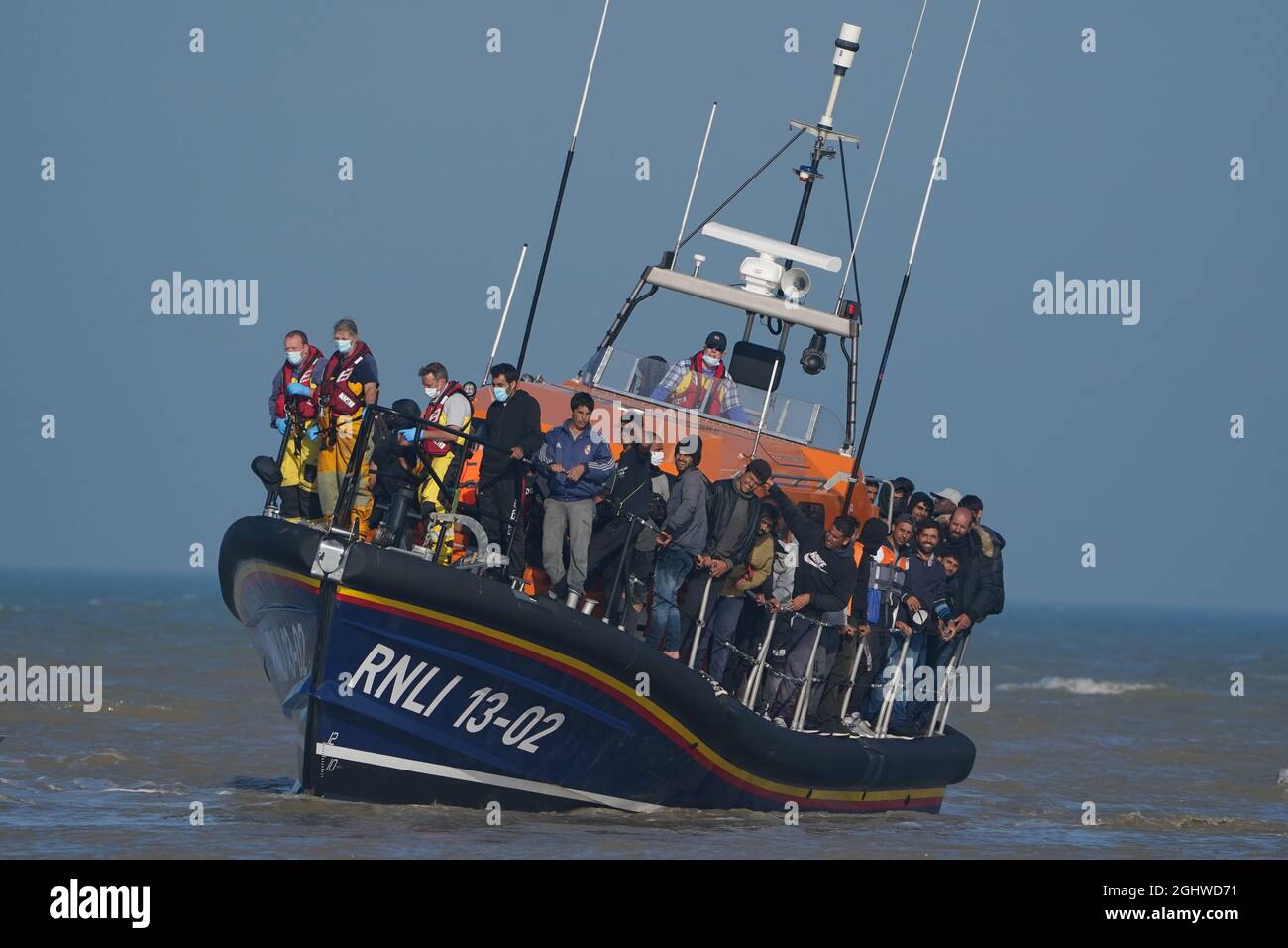 Eine Gruppe von Menschen, die als Migranten gelten, wird vom lokalen Rettungsboot in Dungeness in Kent an Land gebracht, nachdem sie nach einem Vorfall mit einem kleinen Boot im Kanal abgeholt wurde. Bilddatum: Dienstag, 7. September 2021. Stockfoto
