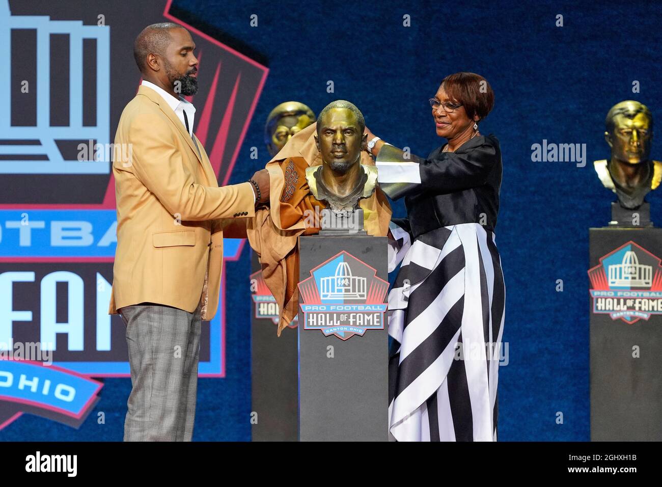 Der Induktionsspritzer Charles Woodson und seine Moderatorin, Mutter Georgia Woodson, enthüllen die Büste von Charleswährend der Pro Football Hall of Fame Class of 2021 in der Einschreibung Stockfoto