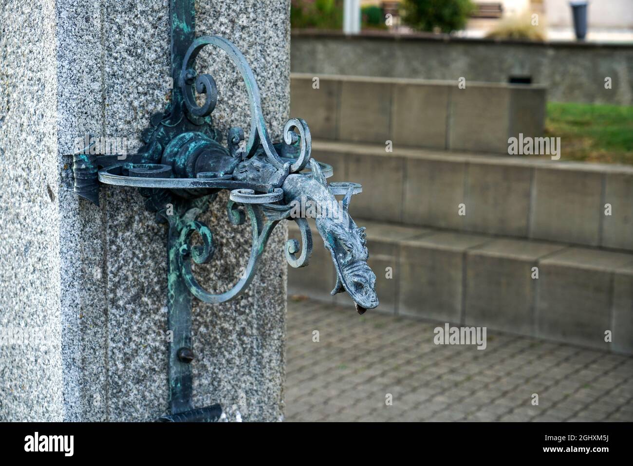 Nahaufnahme eines Vintage-Wassermischers in Schlangenform auf einer Steinsäule im Freien Stockfoto