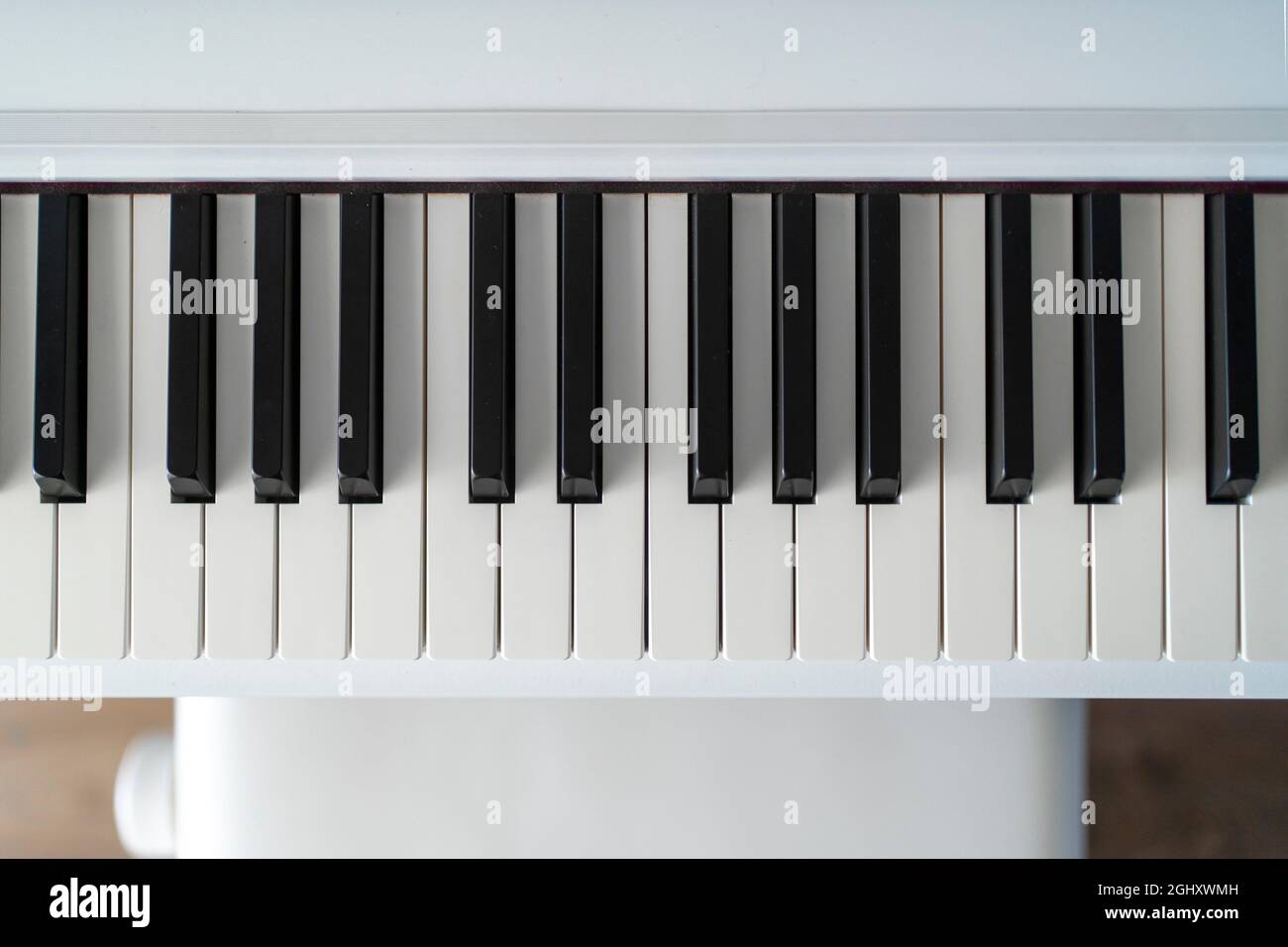 Klaviertastatur. Klassische Musik auf elektronischem Digitalpiano. Blick von der flachen Oberseite auf Holzboden. Wunderschöne weiße Klaviertasten. Stockfoto