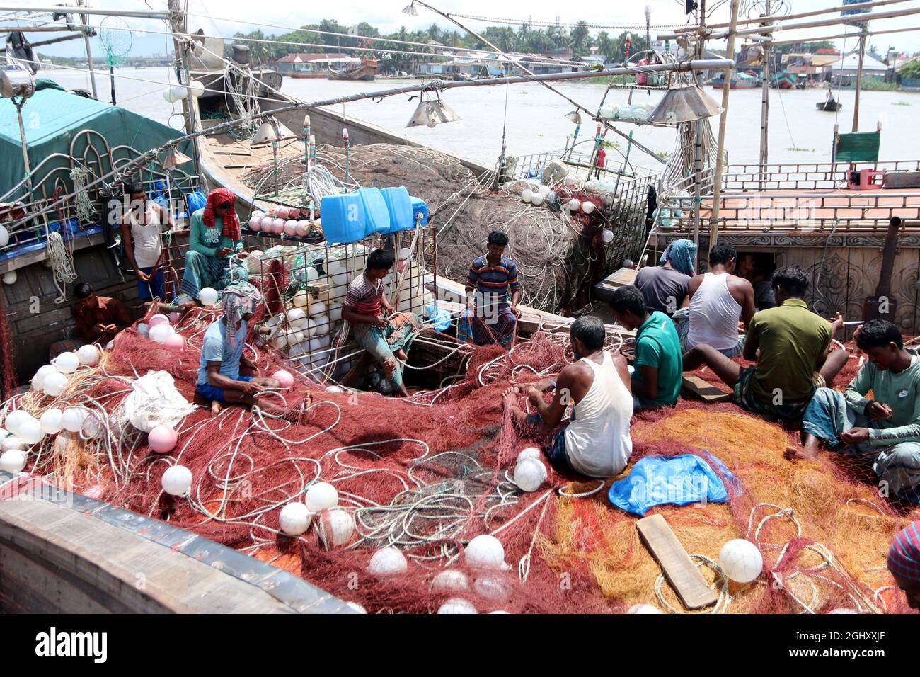 Bahnhof Chandpur Boro. Am 7. September 2021 Repariert Ein Fischer ein Fischernetz auf dem Boot. Chandpur Fischmarkt ist der größte Großhandelsmarkt des Landes, große Mengen von Ilish Fisch werden jeden Tag aus der Bucht in Chandpur Boro Station vernet. Am 7. September 2021 in Chandpur, Bangladesch. (Foto von Habibur Rahman / Eyepix Group) Stockfoto