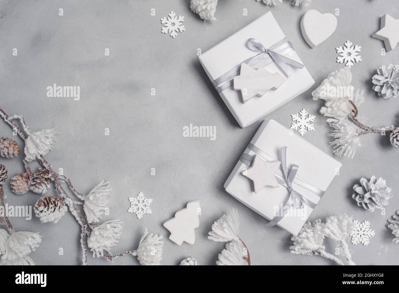 Mockup Weihnachtsrahmen mit Zapfen und Holzspielzeug und Geschenkboxen Grenze über grauen abstrakten Hintergrund, mit Platz für Ihren Text Stockfoto