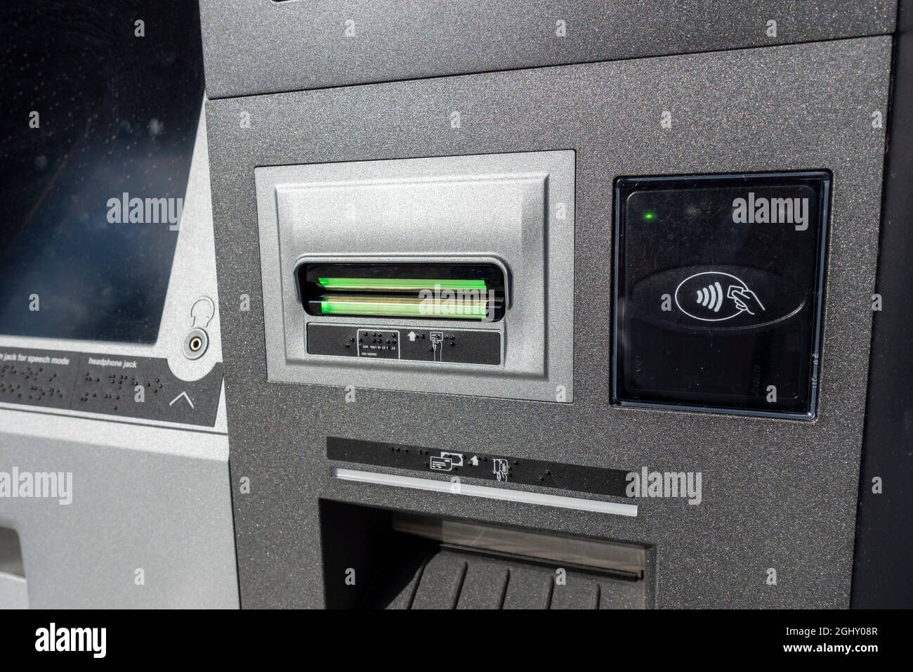 Nahaufnahme eines Einsteckplatzes für eine ATM-Karte und Antippen, um einen Platz außerhalb eines Bankgebäudes zu scannen. Stockfoto