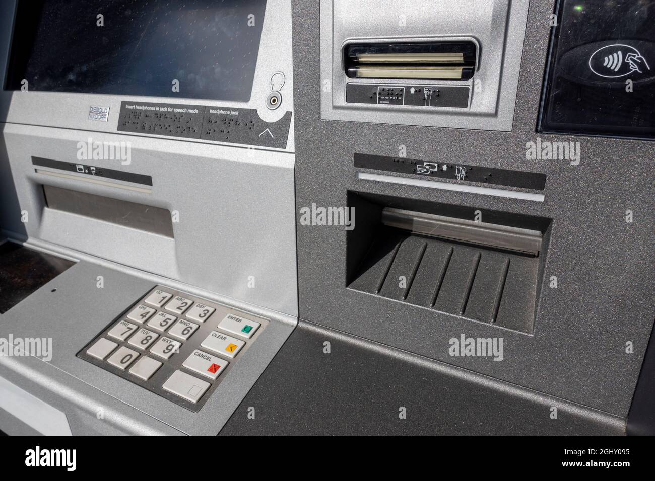 Abgewinkelte Ansicht eines Geldautomaten mit Zahlungspads und eines Scheckeingabeplatzes an einem Außenautomaten außerhalb einer Bank. Stockfoto