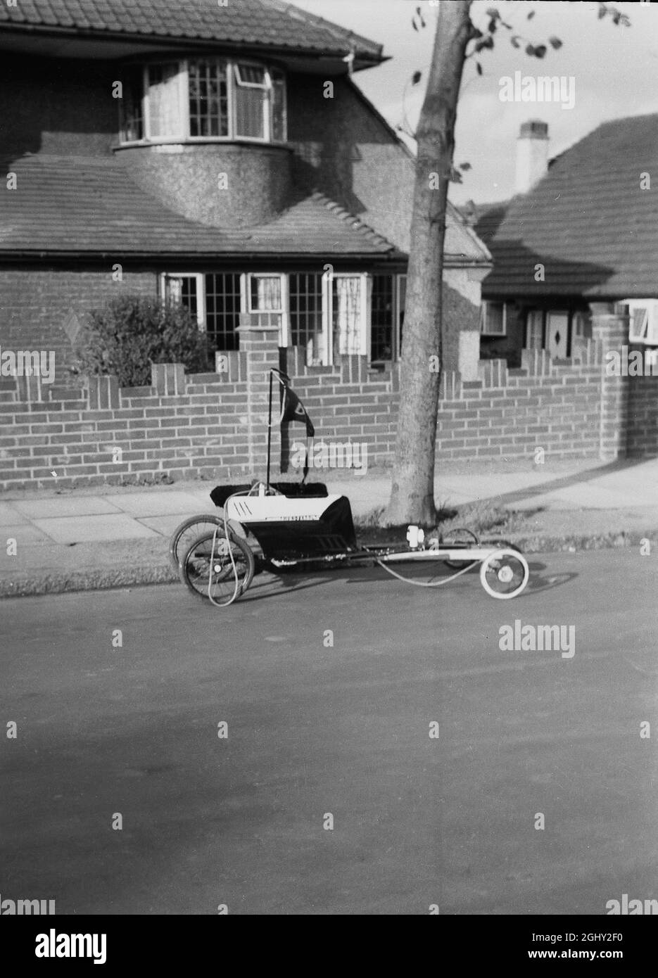 1960s, historisch, ein selbstgemachter Go-Cart der Zeit, geparkt auf einer Vorstadtstraße, England, Großbritannien. Eine DIY-Maschine, die aus alten Holzstücken hergestellt wurde, die an Kinderwagenrädern befestigt und mit einem Stück Seil gesteuert wurden, war ein beliebtes Spielobjekt für Jungen in den späten 50er/frühen 60er Jahren, als sie allgemein als „Trolleys“ bekannt waren. Stockfoto