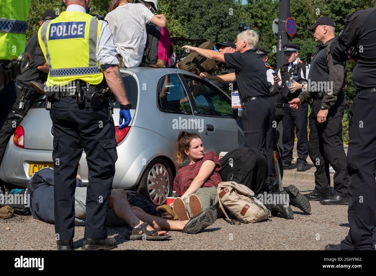 London, Großbritannien. September 2021. Ein Protestler, der gegen die Waffenmesse demonstriert, als die Polizei beginnt, entfernt sie, da sie sich in und um ein Auto auf der A1020 verklebt haben, das den Zugang zu dem Bau in Excel London für die DSEI (Defence and Security Equipment International) blockiert. Die vom 14. Bis 17. September stattfinden soll. Kredit: SOPA Images Limited/Alamy Live Nachrichten Stockfoto