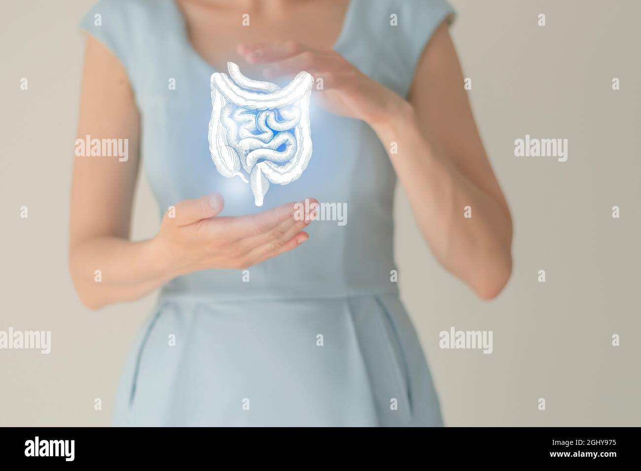 Nicht erkennbare weibliche Patientin in blauer Kleidung, hervorgehobener, von Hand gezogener Darm in den Händen. Menschliches Verdauungssystem Fragen Konzept. Stockfoto