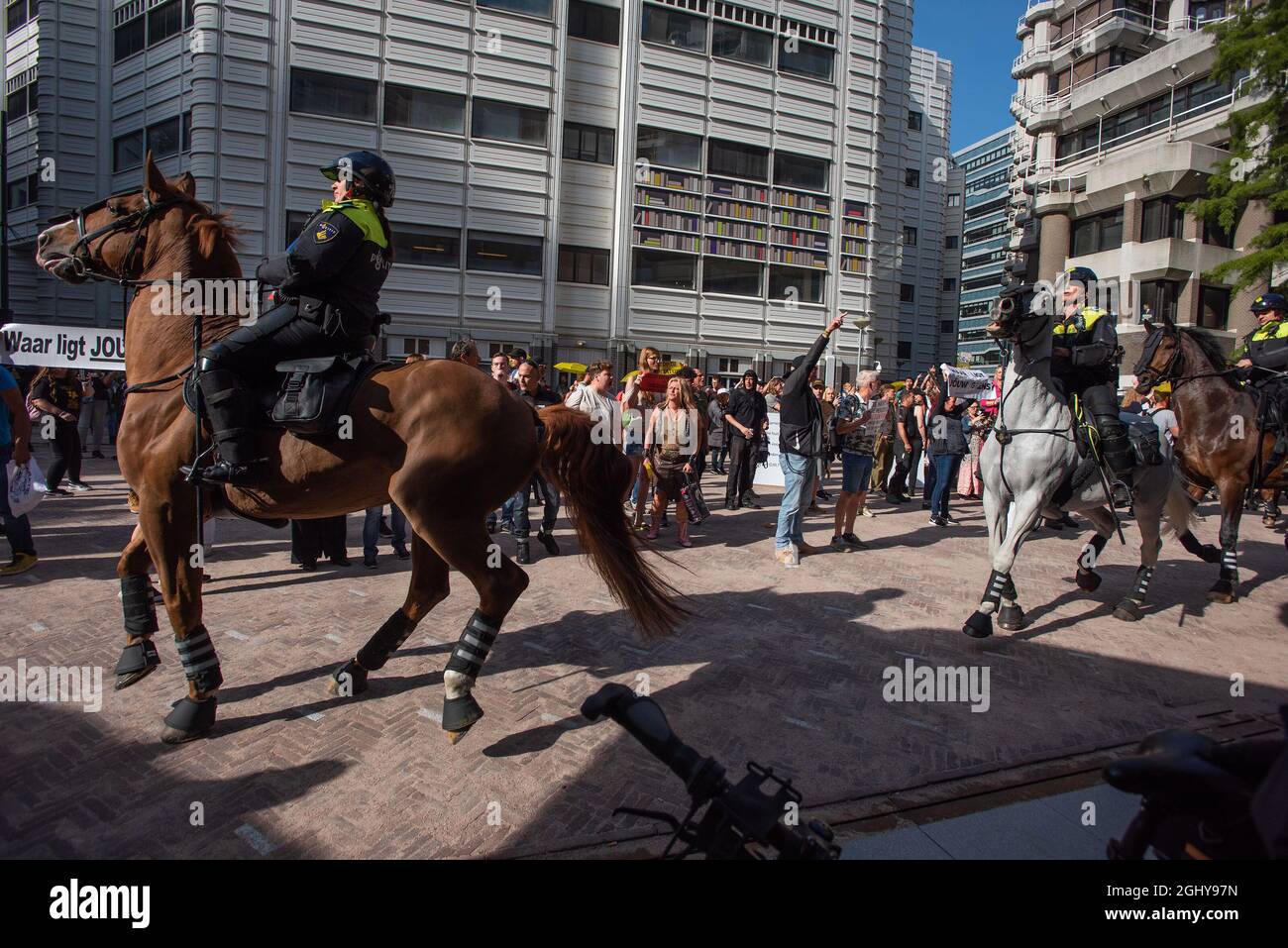 Berittene Polizisten betreten den neuen Parlamentskomplex in Den Haag; ein provisorisches Gebäude, da das alte Gebäude renoviert wird. Die Demonstranten bezeichnen die Polizei als faschistisch und die Niederlande als einen faschistischen Staat und verurteilen die Maßnahmen von Covid-19 im Allgemeinen. Während die Demonstranten niederländische Parlamentarier nach ihrer Rückkehr aus einer Sommerpause willkommen heißen, versammelten Sich heute Morgen Einige hundert Demonstranten vor dem neuen niederländischen parlamentsgebäude, um gegen die Maßnahmen der Corona zu demonstrieren. Und was sie als diktatorische Regierung betrachten. Das Gebäude ist ein vorübergehendes Zuhause, da die Renovierung des Binnenhofs den Sitz der niederländischen Regierung wird Stockfoto