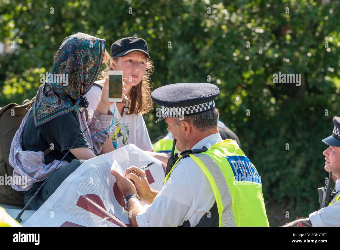 London, Großbritannien. September 2021. Demonstranten, die gegen die Waffenmesse auf einem Auto sind, als die Polizei sie auszieht, da sie sich in ein Auto auf der A1020 eingeklebt und den Zugang zu dem für die DSEI (Defence and Security Equipment International) in Excel London aufgestellten Fahrzeug blockiert haben Die vom 14. Bis 17. September stattfinden soll. (Foto von Dave Rushen/SOPA Images/Sipa USA) Quelle: SIPA USA/Alamy Live News Stockfoto