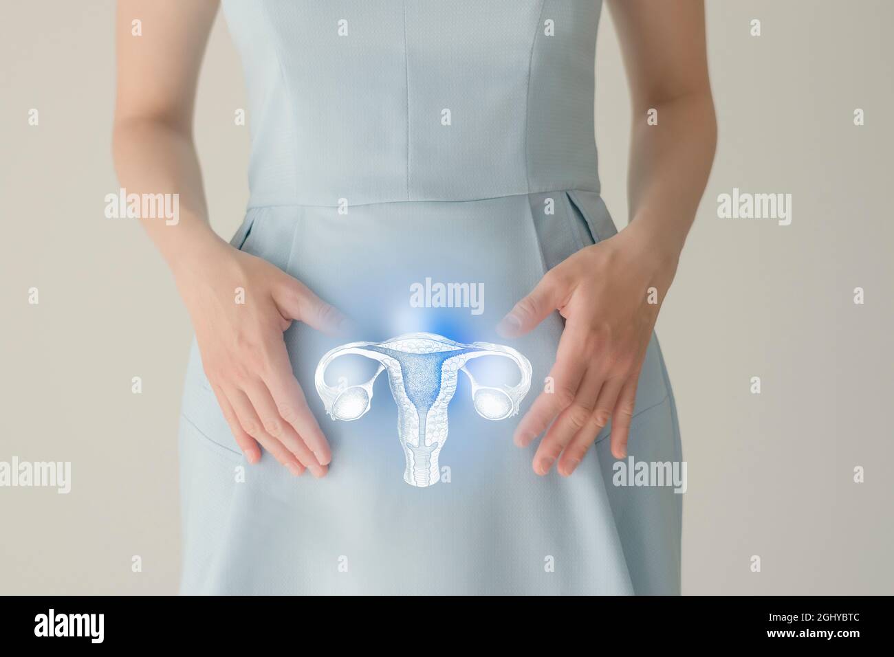 Nicht erkennbare Patientin in blauer Kleidung, in den Händen durch Handzeichen hervorgehobener Uterus. Menschliches Fortpflanzungssystem gibt Konzept aus. Stockfoto