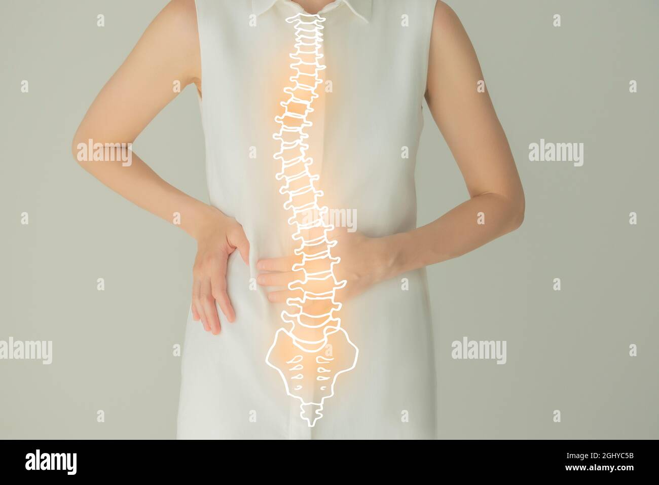 Nicht erkennbare weibliche Patientin in weißer Kleidung, hervorgehobene, von Hand gezogene Wirbelsäule. Konzept zu Problemen mit der menschlichen Wirbelsäulenstruktur. Stockfoto