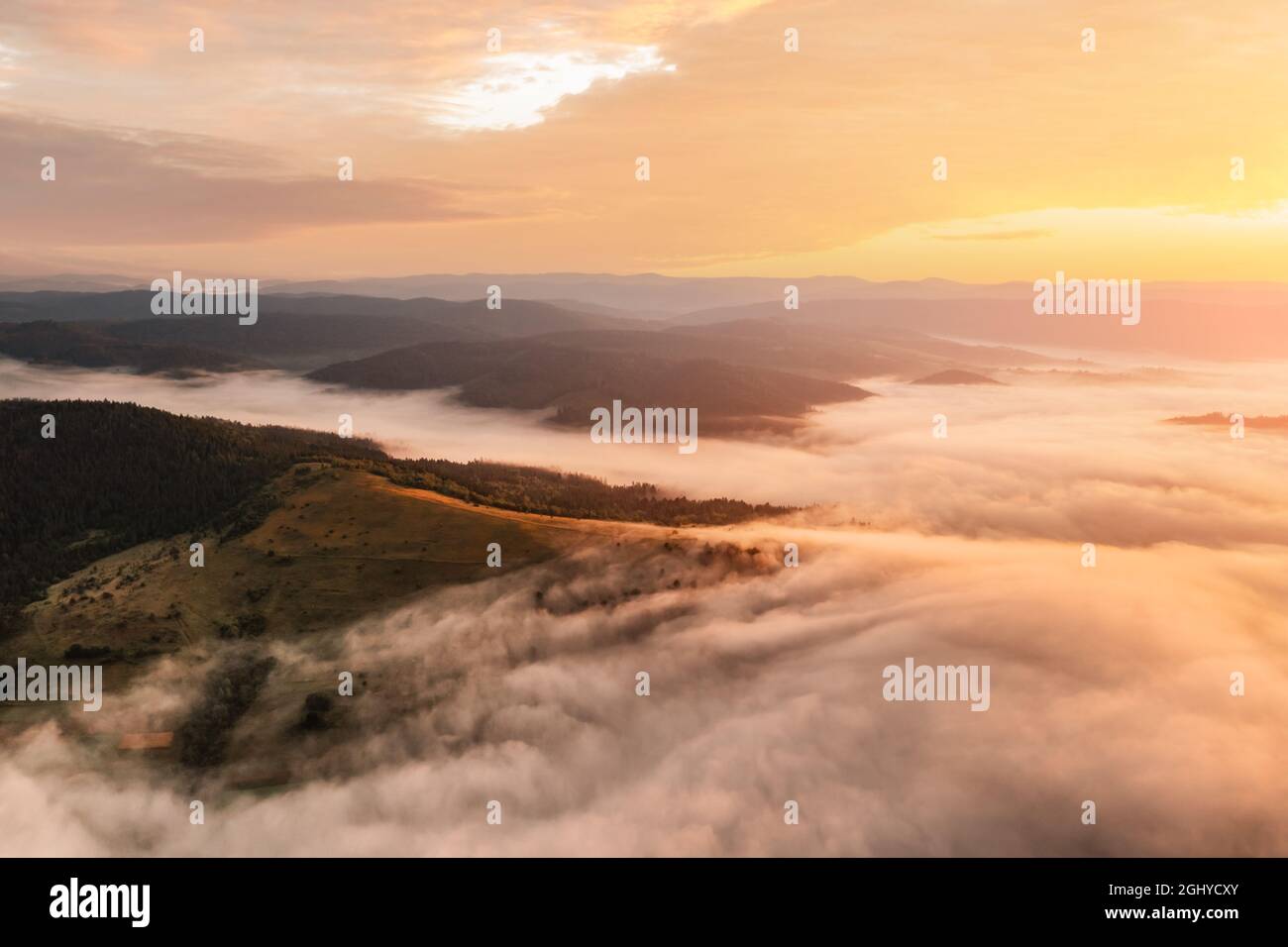 Erstaunlich fließender Morgennebel in den Sommerbergen. Wunderschöner Sonnenaufgang im Hintergrund. Landschaftsfotografie Stockfoto