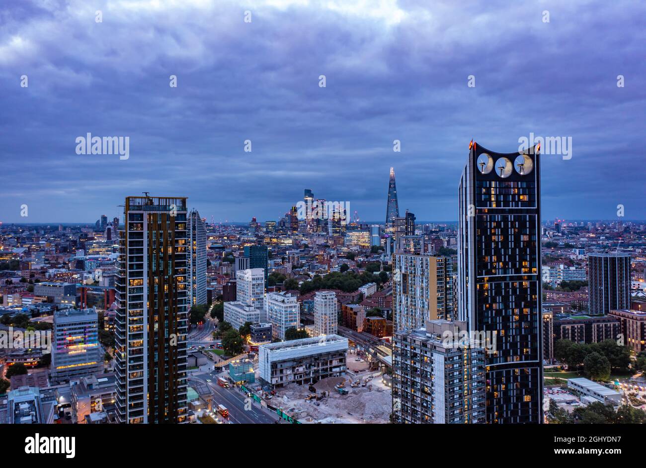 Hohe Wolkenkratzer im Finanzbereich, umgeben von kleinen Gebäuden in der wunderschönen Stadt London, an einem bewölkten Tag mit blauem Himmel Stockfoto