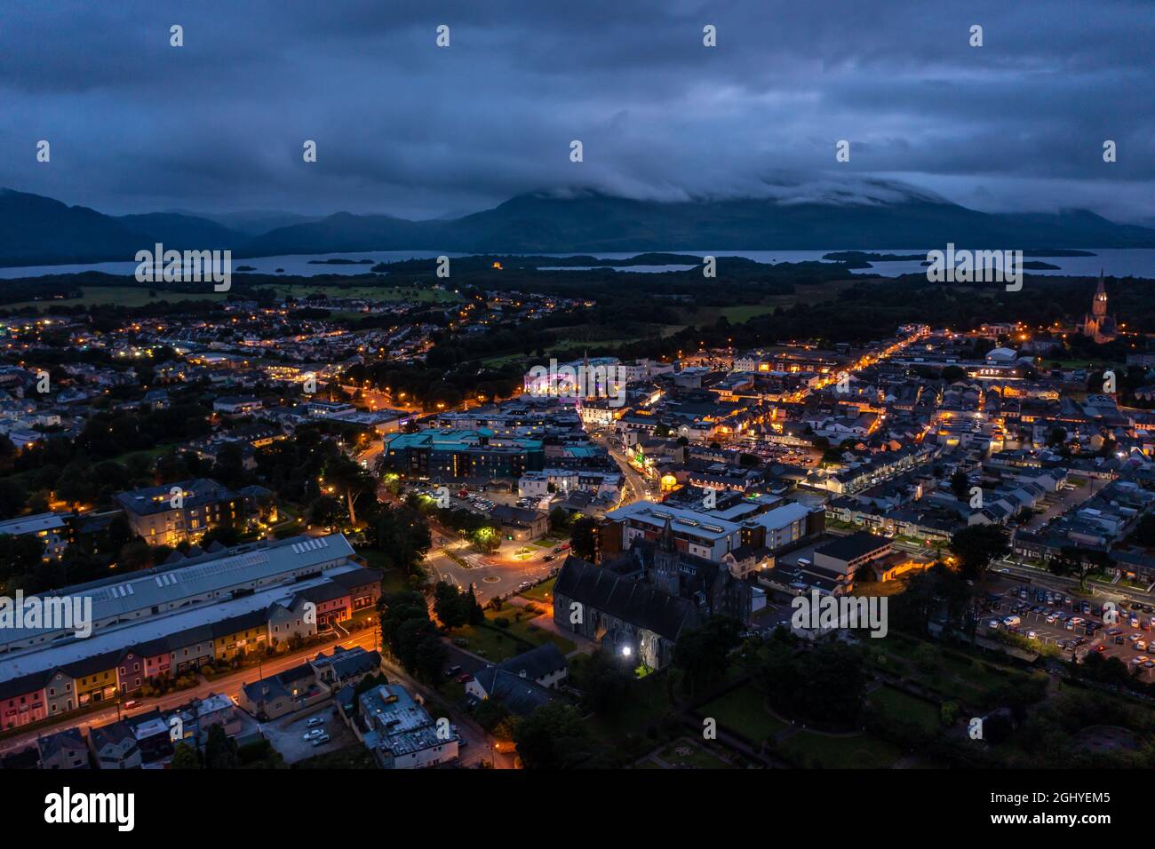 Luftaufnahme der malerischen Touristenstadt Killarney im County Kerry in Irland mit eingeschalteten Lichtern unter einem bewölkten, frühmorgens bewölkten Himmel Stockfoto