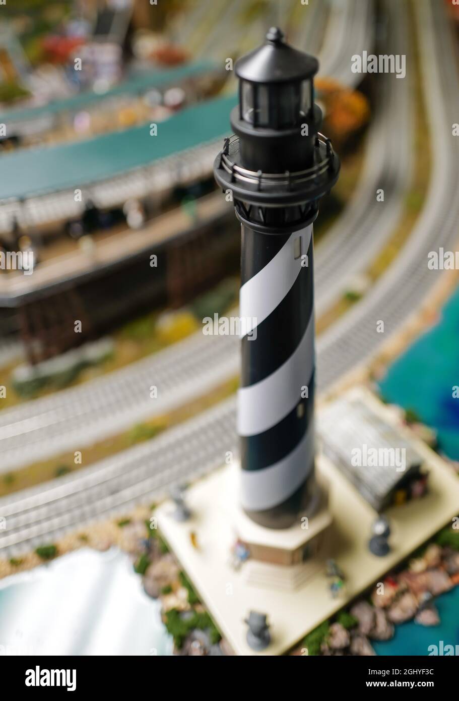 Nahaufnahme von Gleisen, Städten, Gebäuden und Menschen auf dem Spielzeugzug Stockfoto