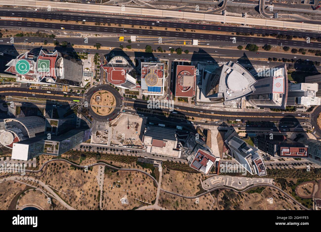 Blick aus der Vogelperspektive auf das Dach des Gebäudes und die Wolkenkratzer mit leerer Straße und Straße in Santa Fe, dem New-Viertel in Mexiko-Stadt tagsüber Stockfoto