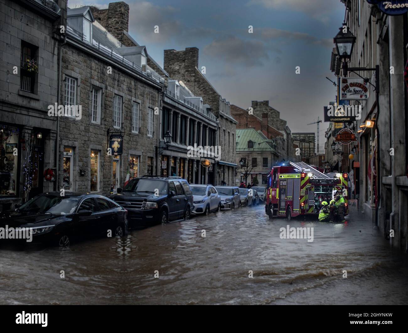 Überflutete Straße mit Feuerwehrleuten, Februar 2021 Feuerwehrleute arbeiten daran, überflutete Grundstücke zu Pumpen. Stockfoto