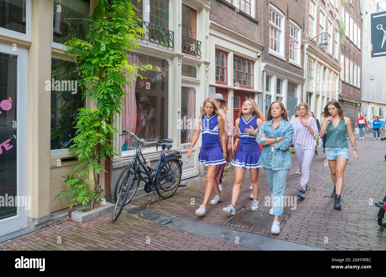 Amsterdam Holland - August 18 2017: Gruppe von jungen Frauen in blauen Kleidern, die in Bewegung auf der Stadtstraße spazierengehen. Stockfoto