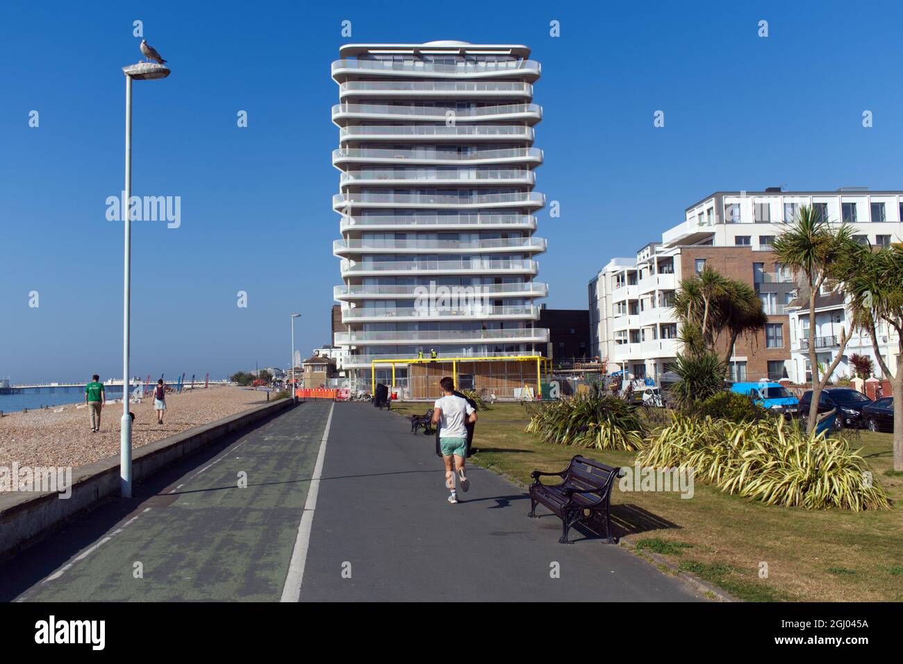 Worthing Promenade von East Beach mit der Neuentwicklung von Bayside Views auf der Seafront mit einem Jogger im Blick. Stockfoto
