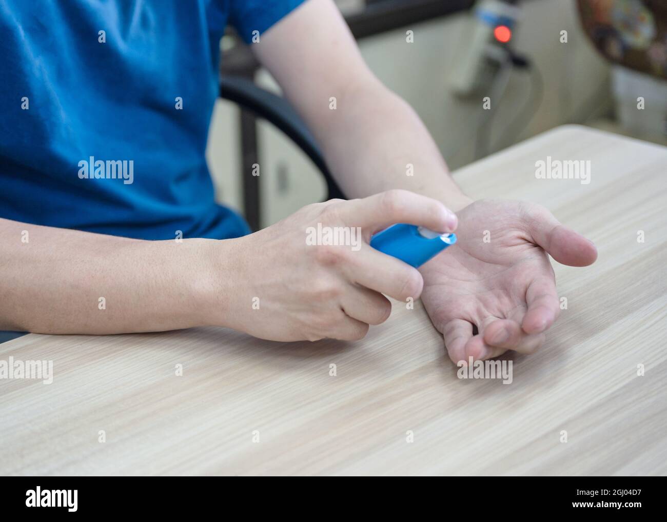 Finger pumpende Alkoholspray auf der Handfläche Stockfoto