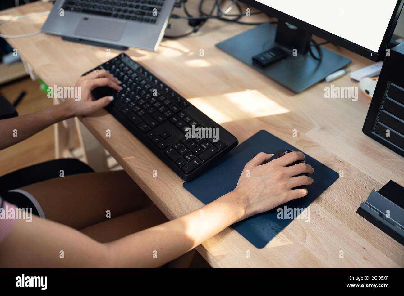 Freiberuflerin arbeitet mit Computer, Tastatur eingeben und mit der Maus auf Holztisch. Arbeit von zu Hause Konzept Stockfoto