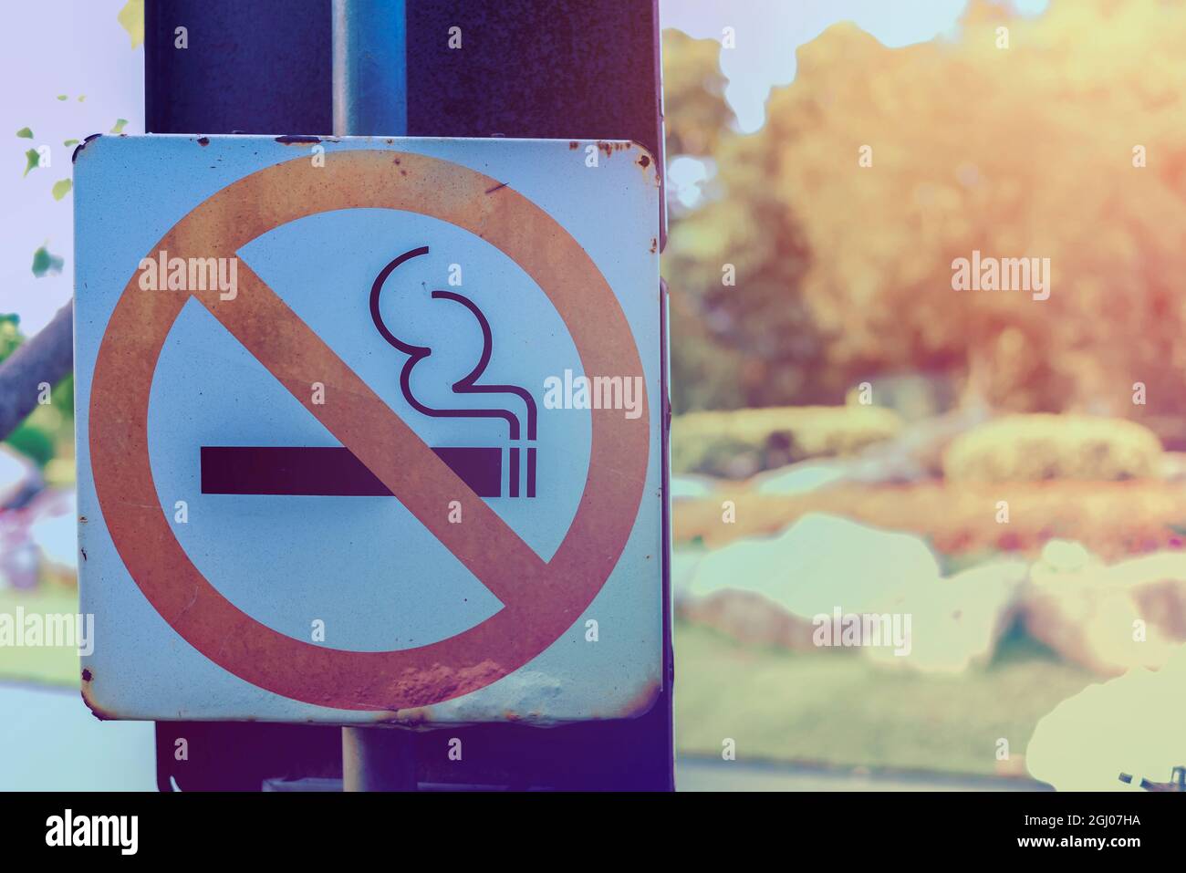 Rauchverbotsschild in der Nähe der Laufbahn im öffentlichen Park. Cross-Processing und Split-Tone neue Trend wie Prozess. Stockfoto