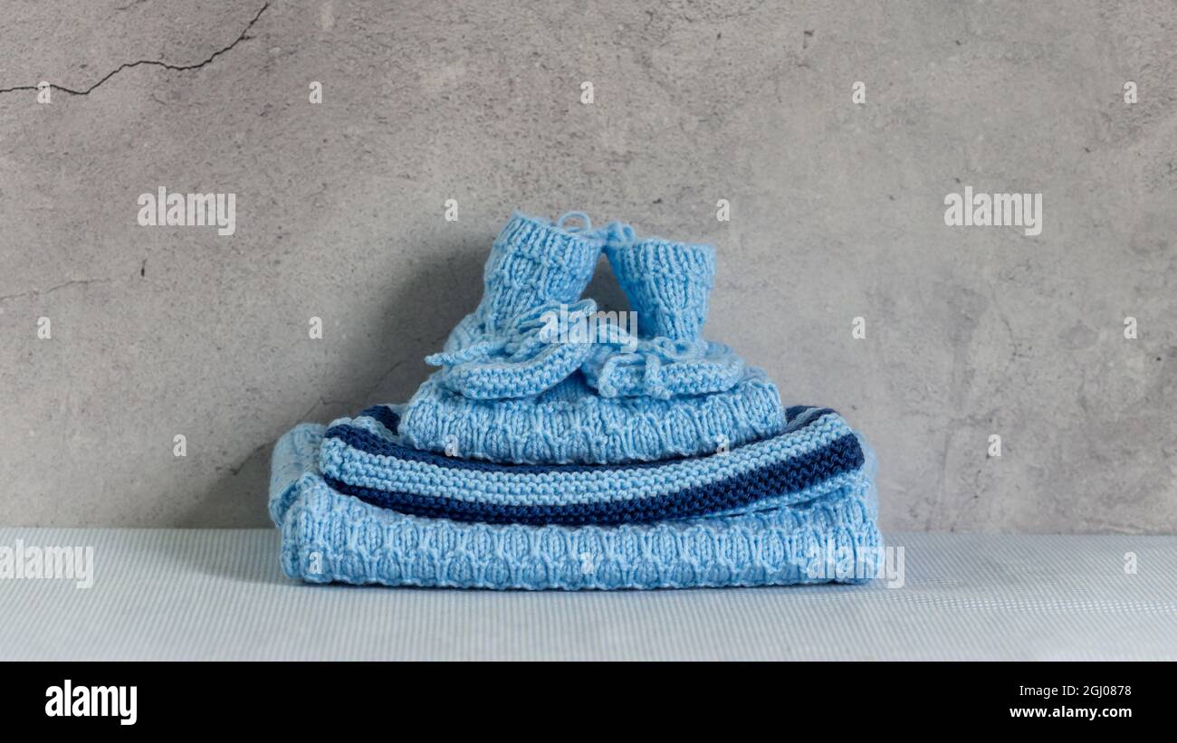 Hausgemachte Kleidung, blaue Strickpullover für Babys. Stockfoto