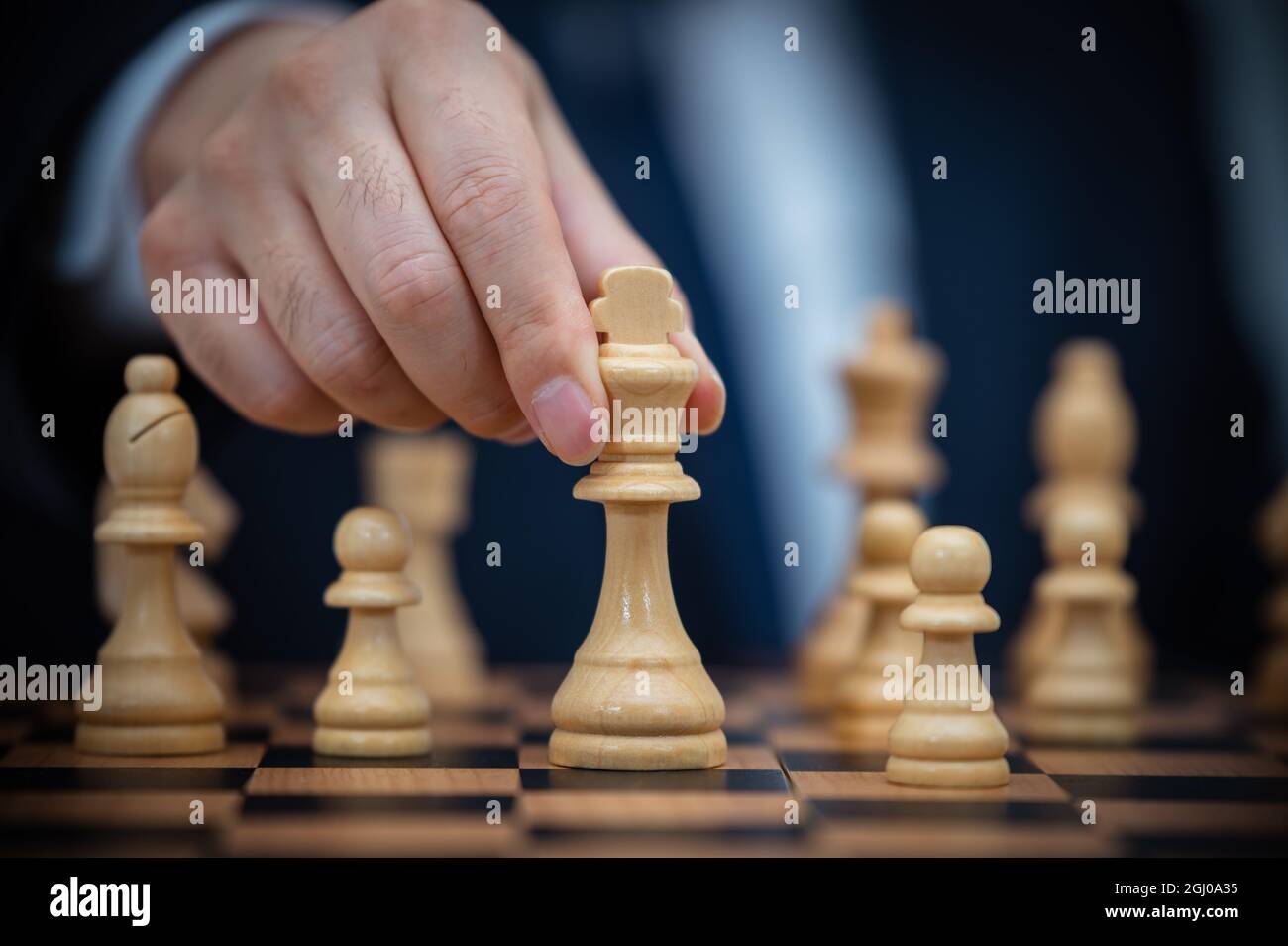 Ein Geschäftsmann in einem Anzug hält einen Schachkönig. Stockfoto