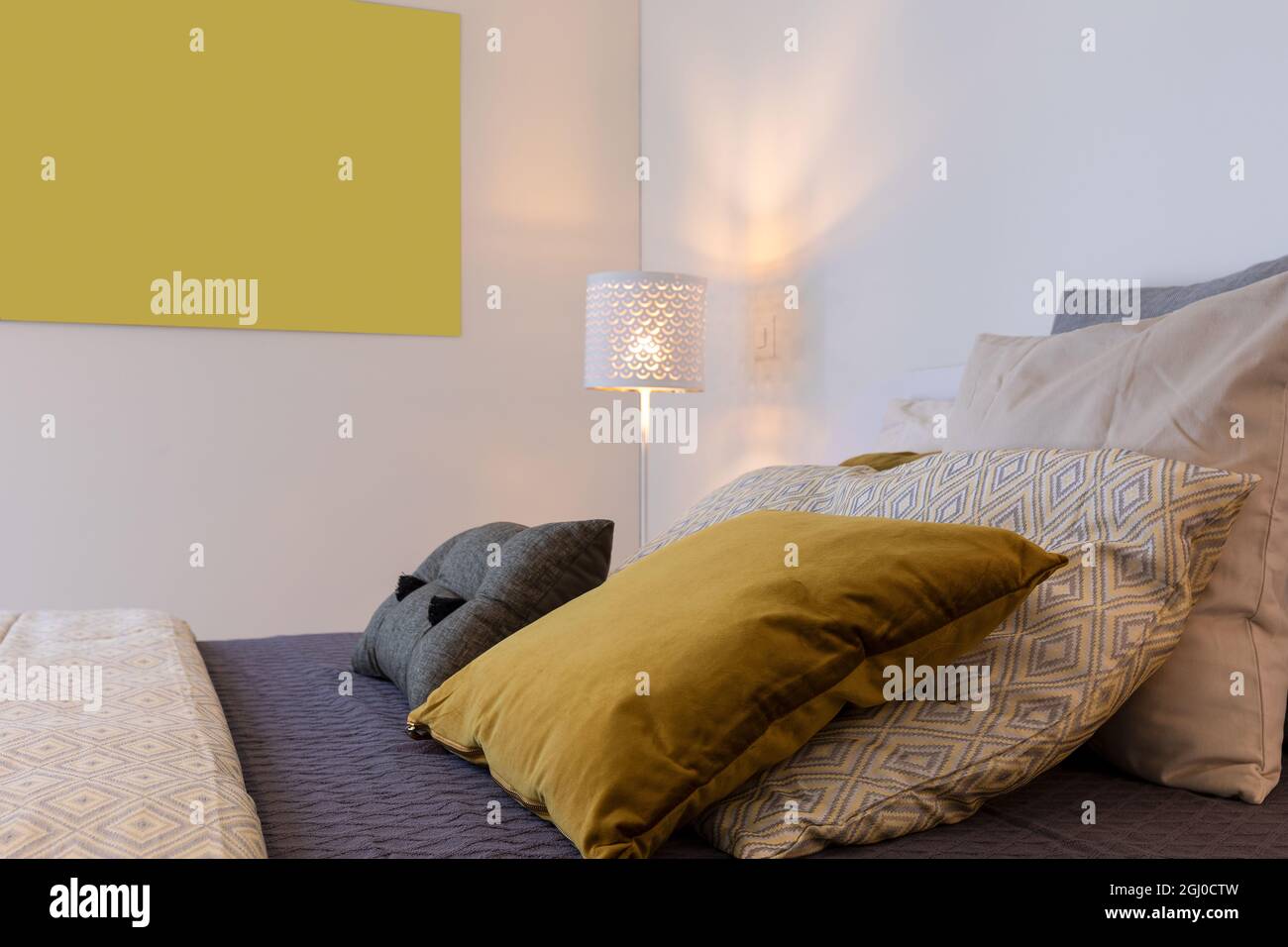 Detail des Bettes mit vielen farbigen Kissen. Ein gemütliches und warmes Schlafzimmer. Stockfoto