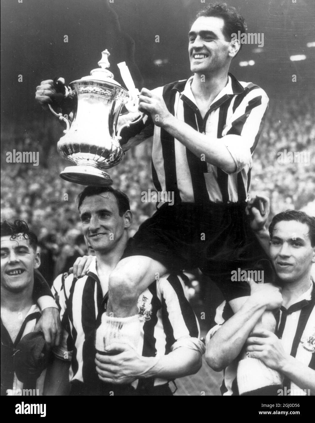 1952 FA Cup Finale Newcastle Utd gegen Arsenal Newcastle Kapitän und rechte Hälfte Joe Harvey wird von seinen Teamkollegen bejubelt, als er im zweiten Jahr in Folge den FA Cup nach dem besiegten Arsenal 1:0 hält. Mai 1952 Stockfoto