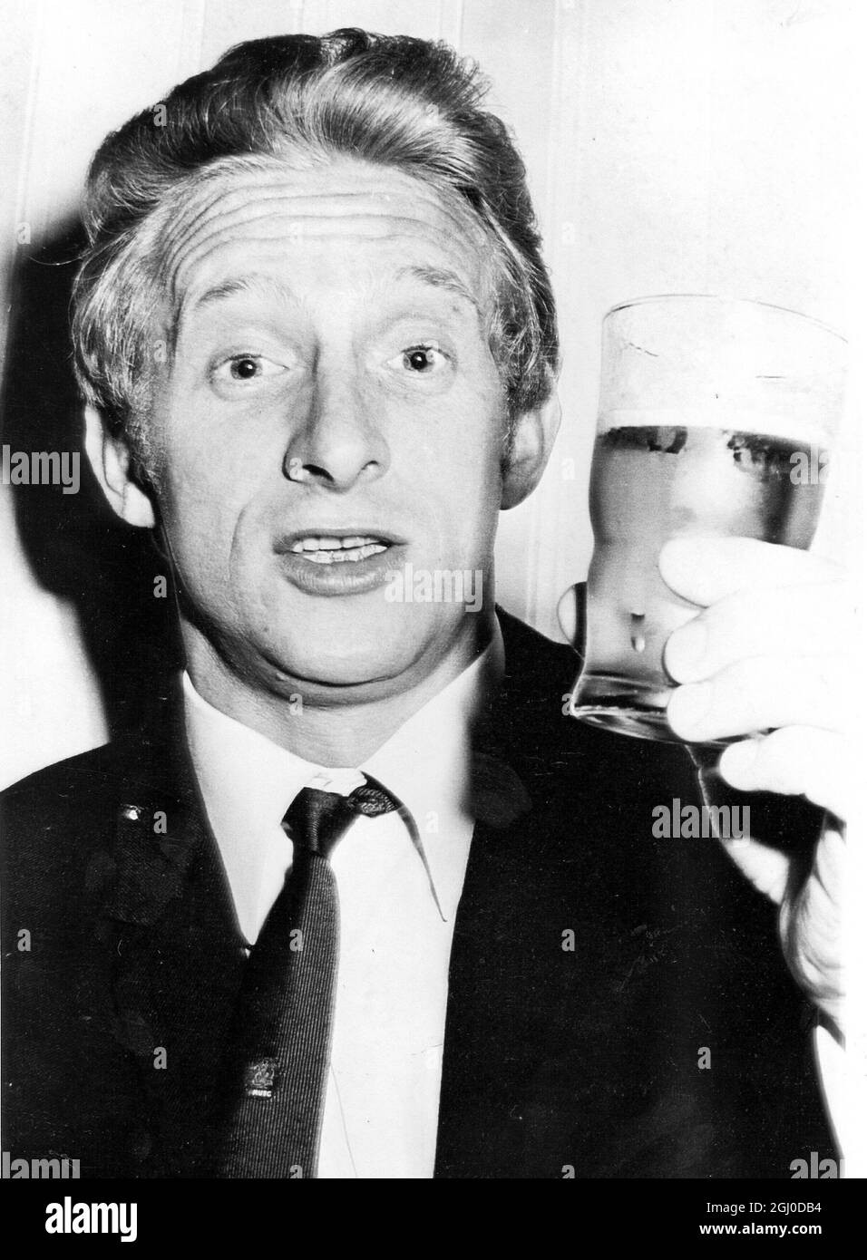 Denis Law probest sein erstes Glas australisches Bier - Englands Fußballweltmeister Manchester United ist vor kurzem aus Neuseeland auf dem Kingsford Smith Airport in Sydney für eine Australienreise mit acht Spielen eingetroffen Manchester United wird am Mittwoch auf dem Showground Sydney spielen und am New South Wales spielen Gleiches Gelände am Sonntag, den 10. Juni - Foto zeigt den schottischen Fußballnationalspieler Denis Law von Manchester United bei seinem ersten Glas australisches Bier bei der Ankunft am Kingsford Smith Airport in Sydney, 5. Juni 1967. Stockfoto