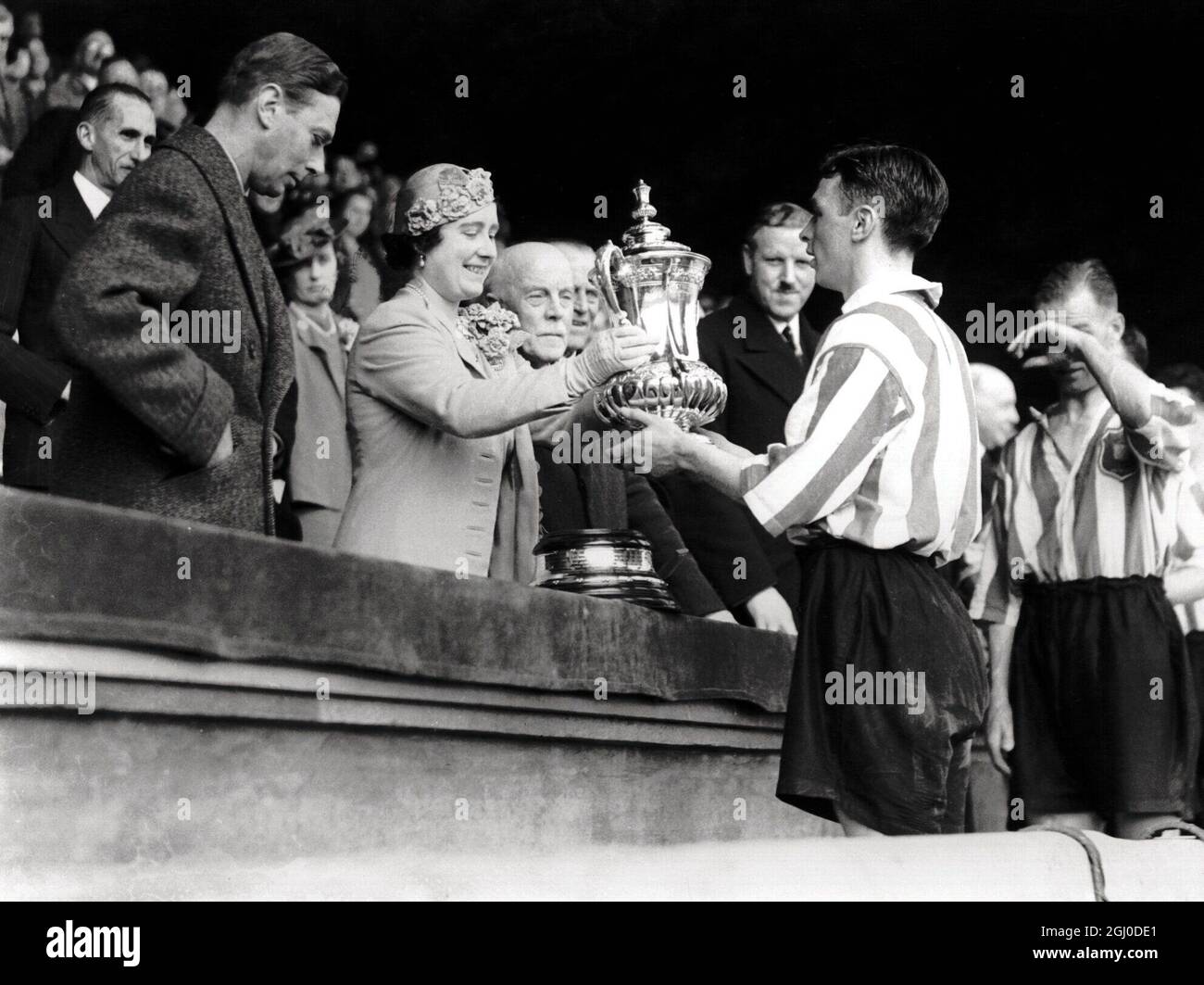 Ihre Majestät, Königin Elizabeth, überreicht die Königin-Mutter den FA-Pokal an H Carter aus Sunderland. Mai 1937 Stockfoto